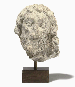 A FRAGMENTARY CARVED LIMESTONE HEAD OF A MALE SAINT  