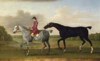 A liver chesnut racehorse led by a mounted groom in a wooded landscape