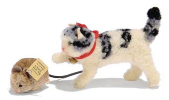 Steiff woolie pom pom calico cat chasing a Steiff woolie pom pom brown mouse