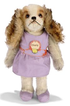 A STEIFF ARCHIVE CHARLY DOLL, (328,6), brown-tipped and white mohair head, white mohair jointed body, brown and black glass eyes, black stitching, swivel head, purple dress and shoes, remains of red silk sash, chest tag and Archive tag 'Charly 328,6 1929 Jnd.10568', 1929-30 --10¾in. (27.5cm.) high (slight fading)