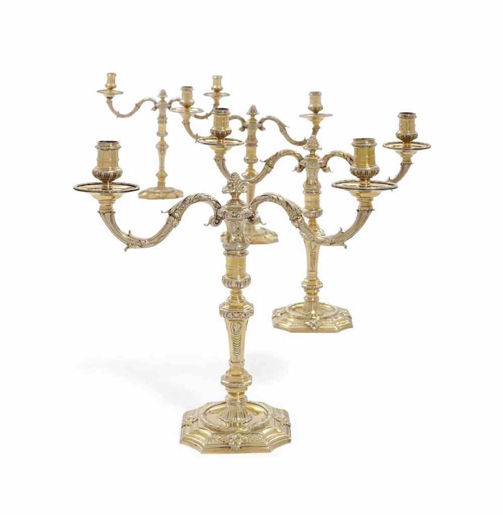 A SET OF FOUR GEORGE II SILVER-GILT CANDLESTICKS WITH A SET ...