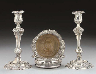 A PAIR OF PLATED CANDLESTICKS IN THE EARLY 19TH CENTURY TAST...