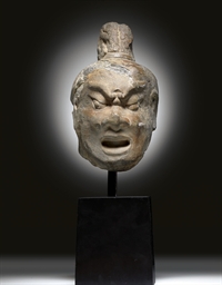 A SMALL GREY LIMESTONE HEAD OF A LOKAPALA