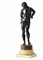 Représenté debout en contrapposte, la tête tournée vers la droite et les mains derrière le dos; sur une plinthe d'époque postérieure en porphyre et en marbre; patine brune à rehauts brun rouge 