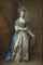Portrait of Mrs. William Villebois, full-length, in masquerade dress, with a blue gown and a lace-edged satin skirt, holding a diaphanous wrap, beside a pilaster