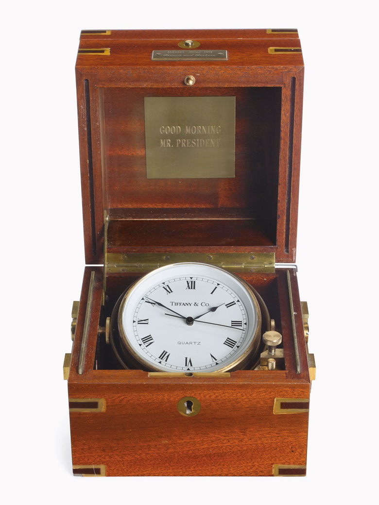 An inaguration gift from Mr. and Mrs. Francis [Frank] Sinatra to President Ronald Reagan, January 20, 1981. An American marine chronometer, by Tiffany, 20th century. The matt silvered dial with Roman numerals, black finished hands, brown bowl, gimballed in brass-bound mahogany box, the hinged lid with a plaque engraved, ‘Good Morning Mr. President’, and dedication plaque to the front,