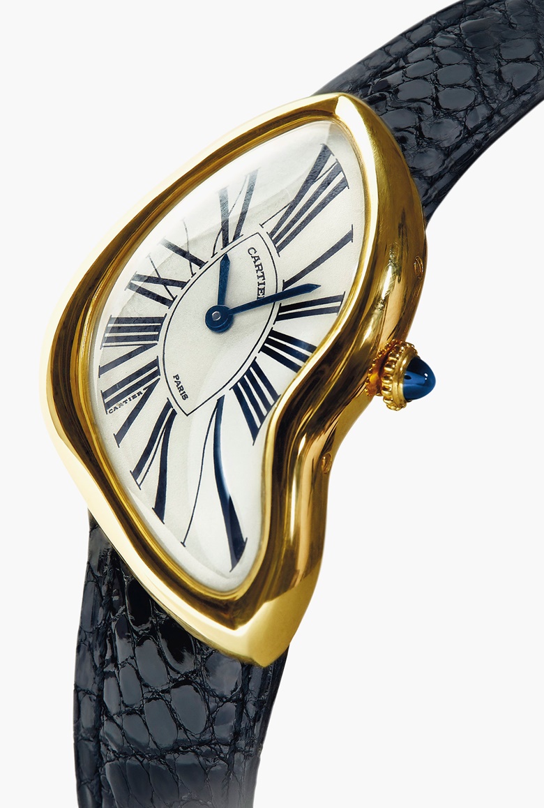 A limited-edition ‘Crash’ wristwatch, 1991, by Cartier. The asymmetrical cream dial with black painted Roman numerals, secret signature at 7 o’clock and blued steel hands, to the polished case and sapphire-set crown, the strap with Cartier deployant clasp, mechanical movement, 1991, case width 25 mm, inner circumference 16.0 cm, with French assay marks for gold. Estimate