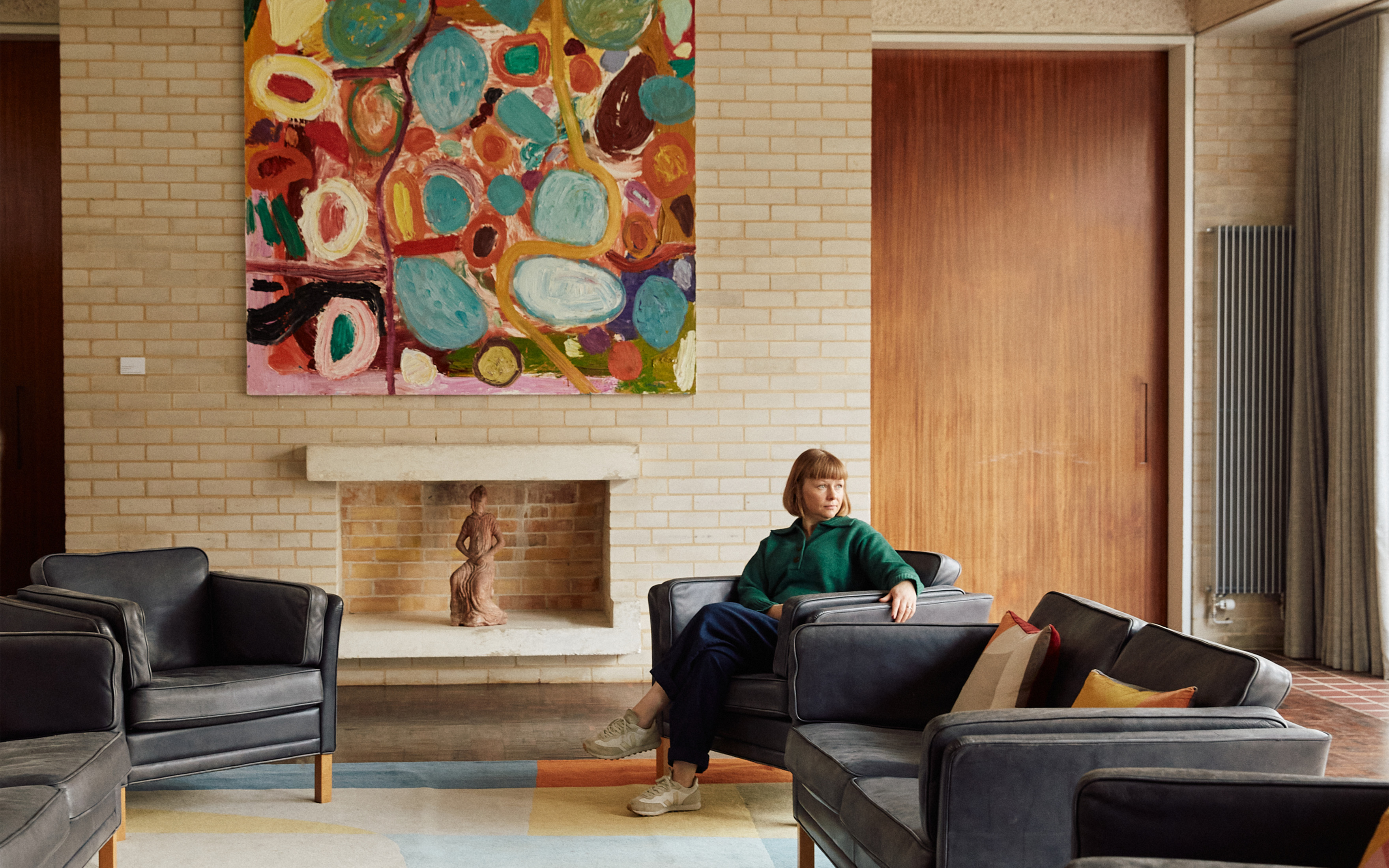 Harriet Loffler, curator of the Women's Art Collection, with Sun Stars Dawn, 1996, by Gillian Ayres. In the fireplace is Angel of the Annunciation, a 1930 sculpture by Renee Hetherington
