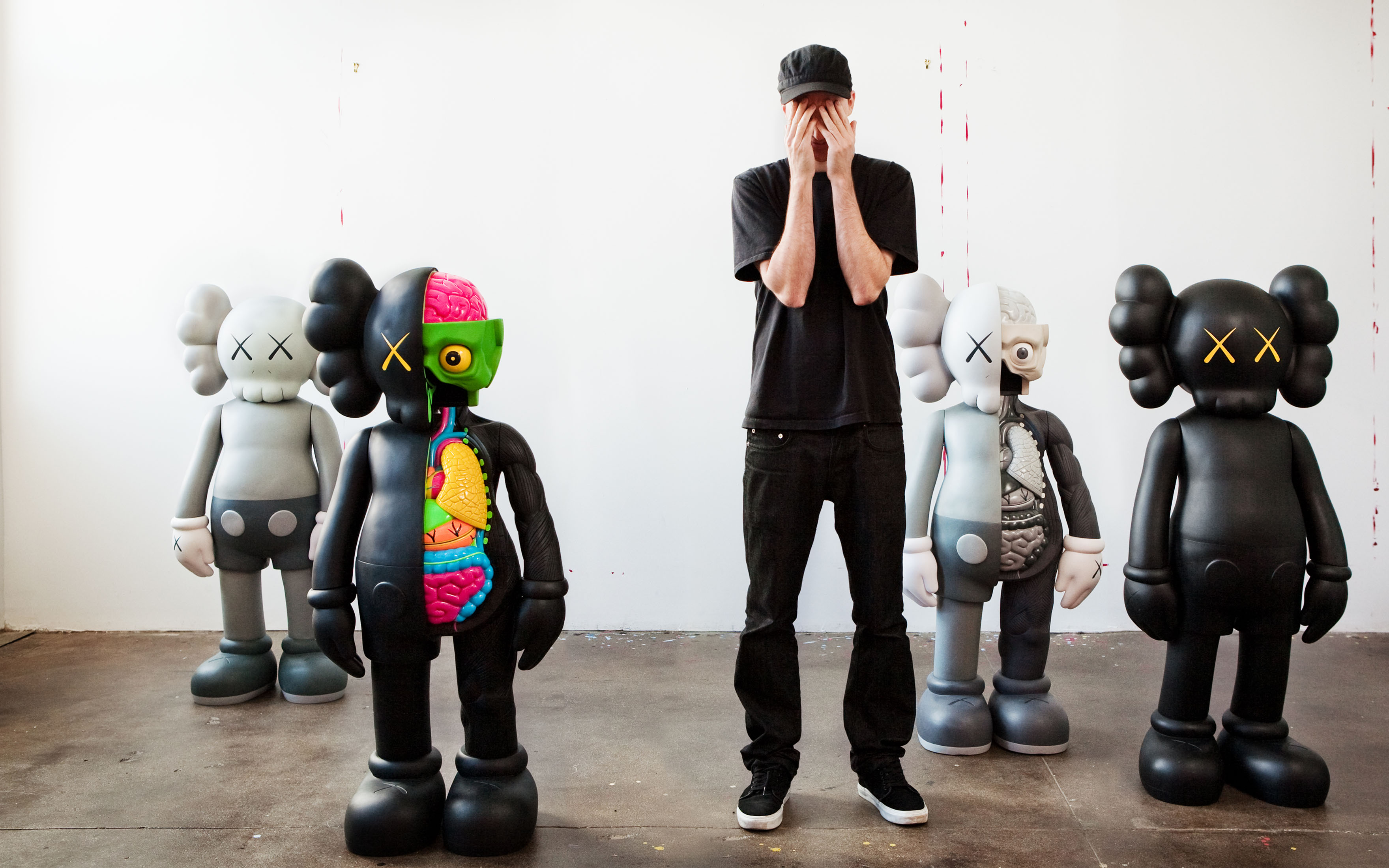 The artist KAWS with a group of works from his COMPANION series