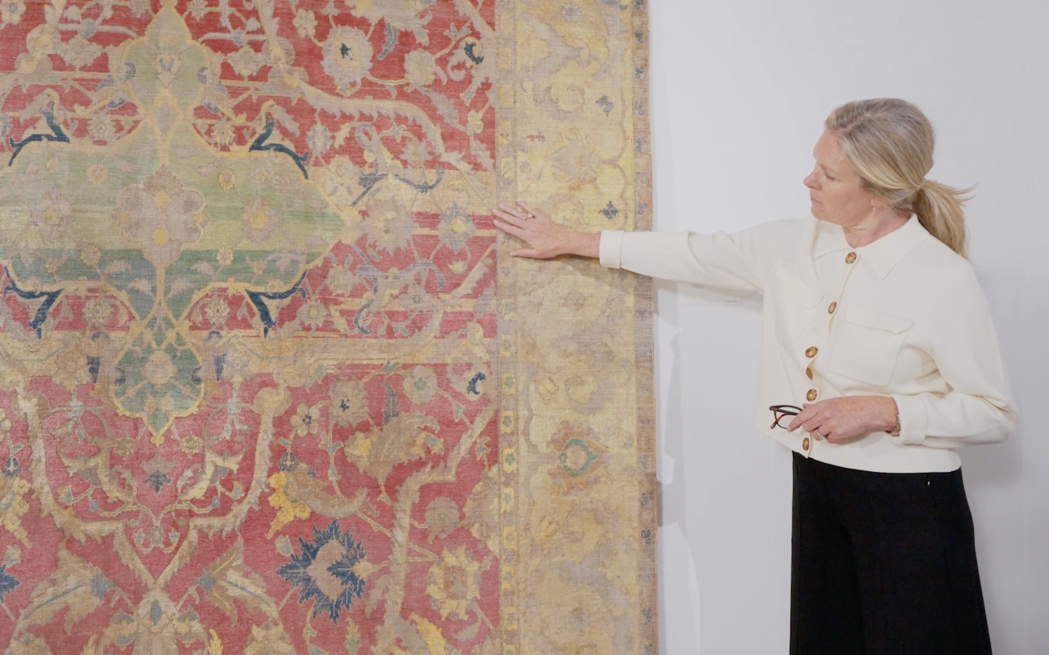 Specialist Louise Broadhurst with the early 17th-century silk Safavid Polonaise carpet offered in Art of the Islamic and Indian Worlds including Rugs and Carpets on 24 October 2024 at Christie's in London