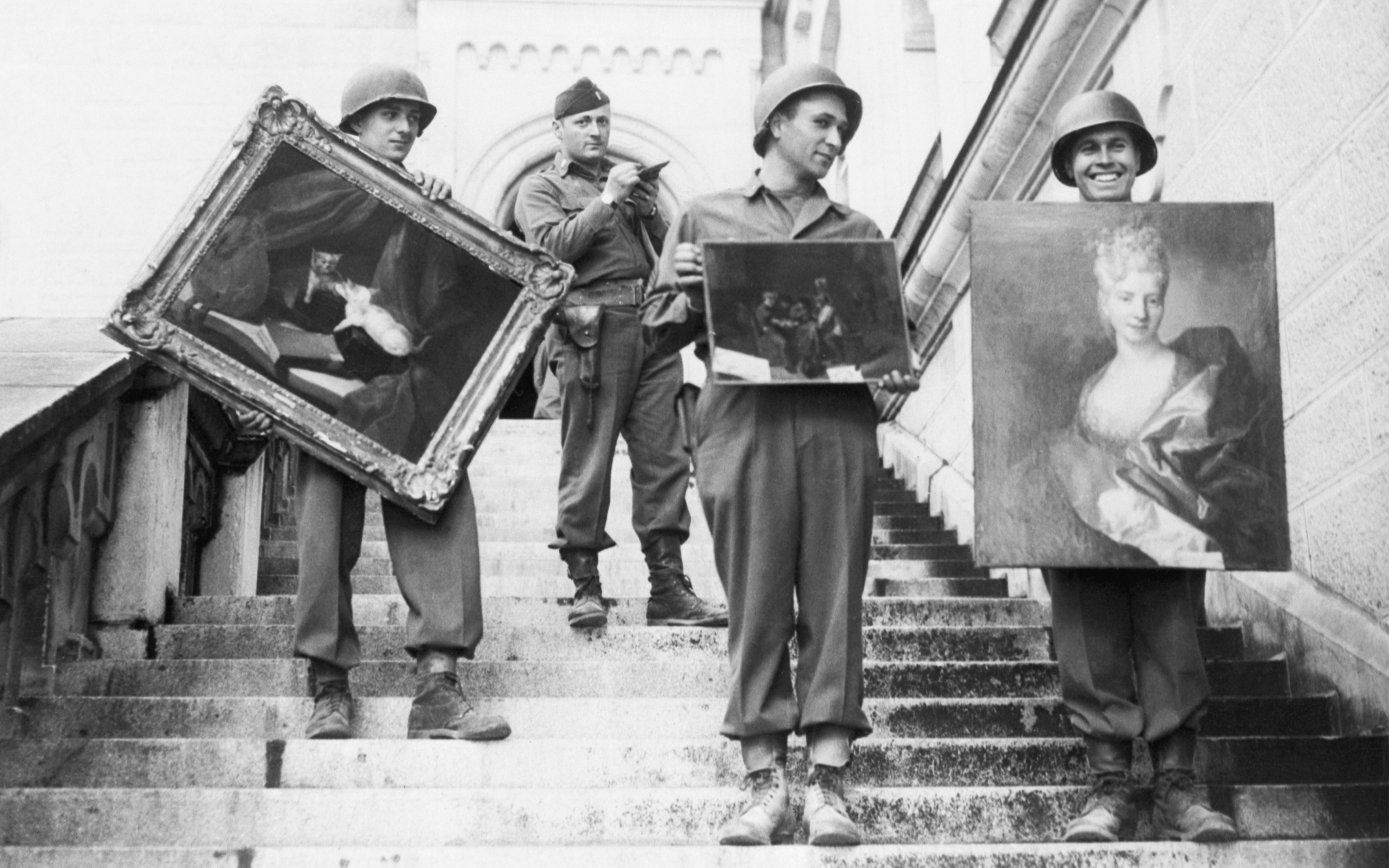 Des soldats de la 7e Armée américaine descendent les marches du château de Neuschwanstein, près de Füssen, en Allemagne, en mai 1945, en transportant des tableaux