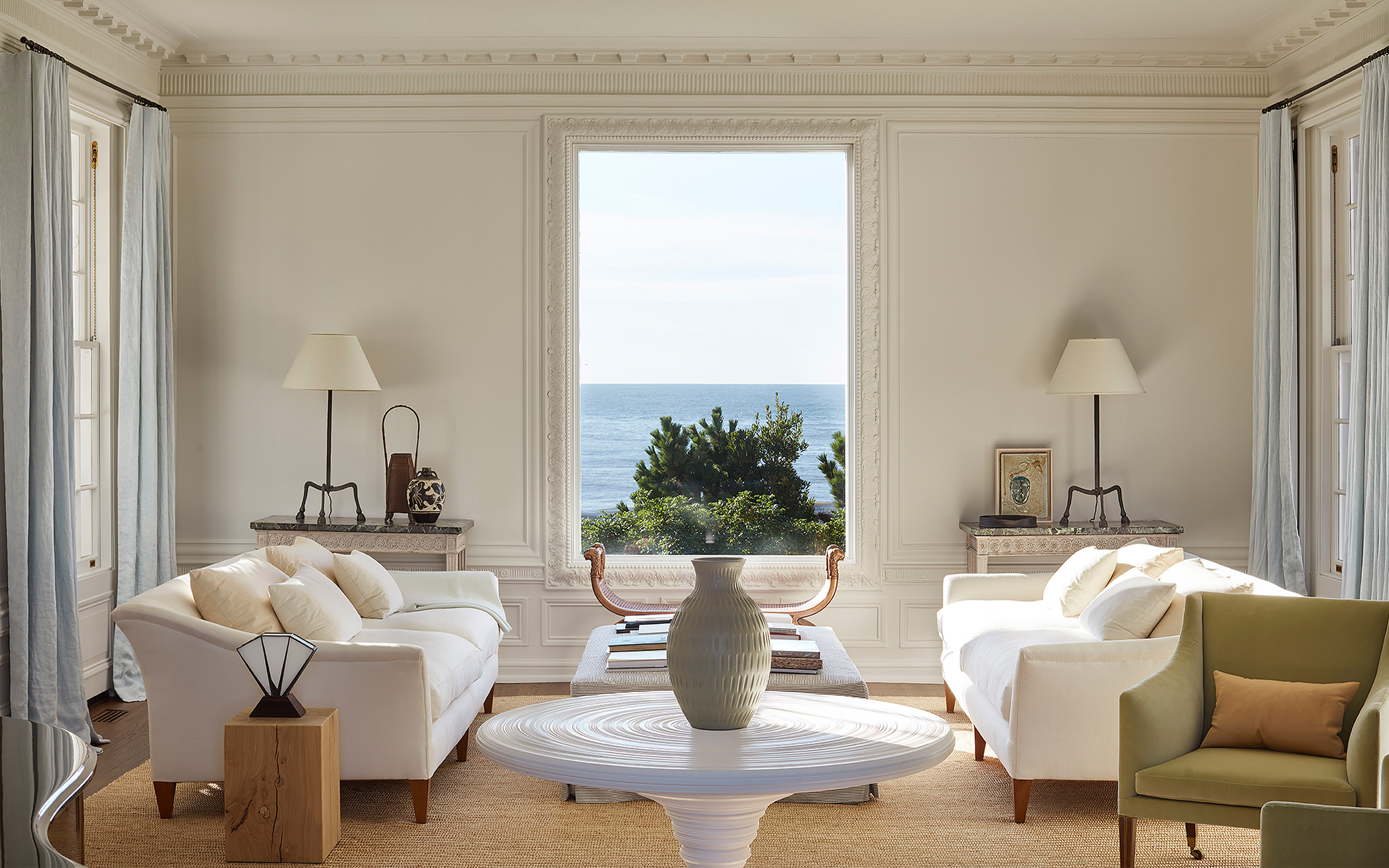 One of Uniacke's interiors: the drawing room of a house built in 1929 by the architect Penrose Stout in East Hampton, New York. ‘The picture windows were a masterstoke, framing the seascape beautifully,' says Uniacke. On the table to the left is a 12th-century Cizhou-ware vase, next to a Rose Uniacke hoof light. In the centre is a Stupa table by Rose Uniacke