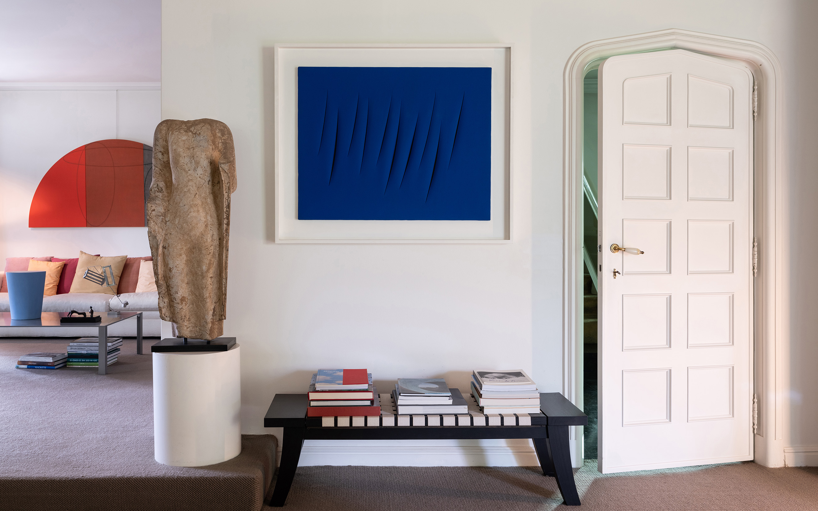 In the the Vanthournout's residence, Lucio Fontana's Concetto spaziale, Attese, 1964, a rare, 10-incision work from the artist's iconic Tagli ('Cuts') cycle. The room to the left features works by Robert Mangold, Ettore Spalletti, Henry Moore and George Rickey