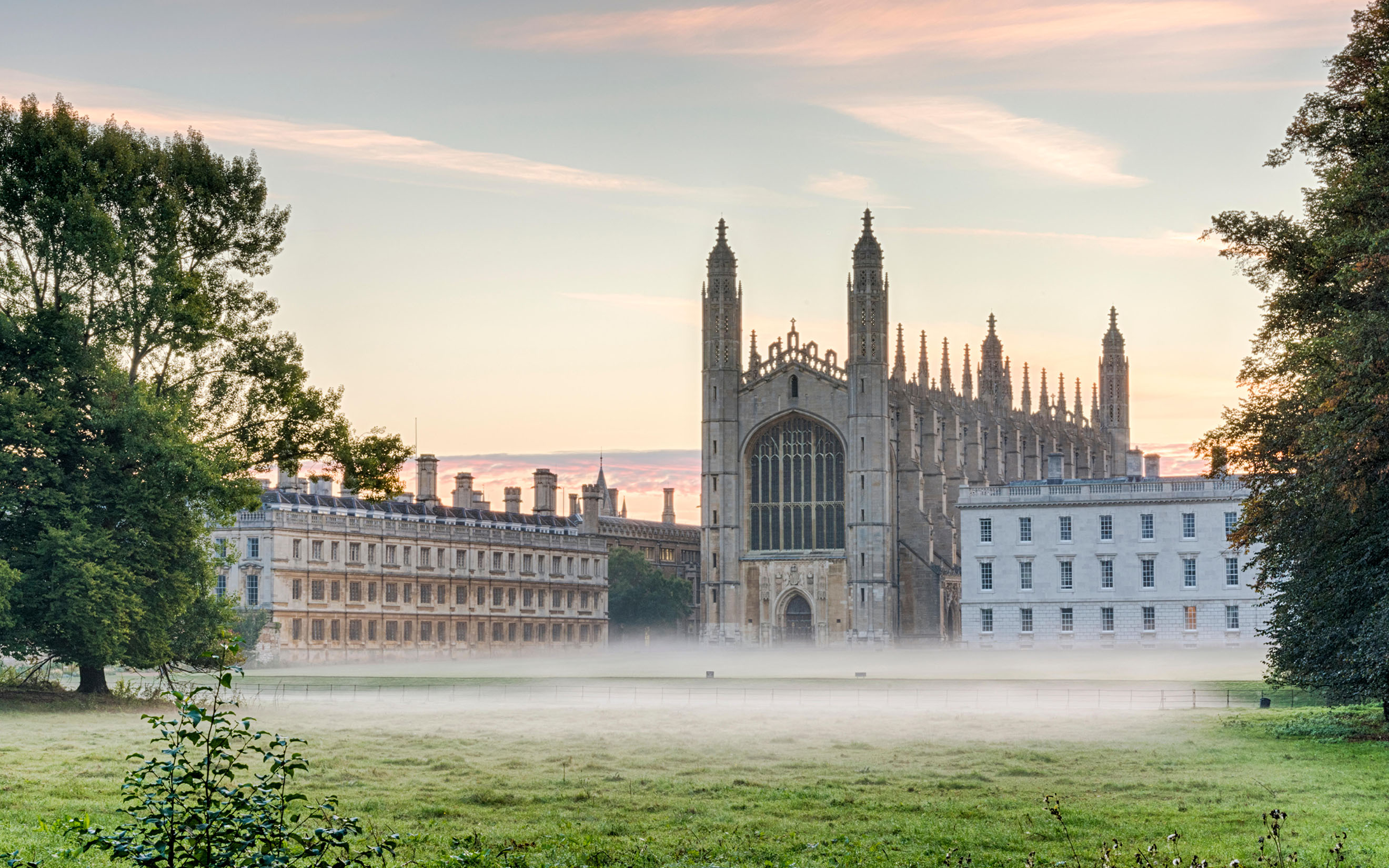Mist hangs in the air and across the lawns of King's College Cambridge at dawn