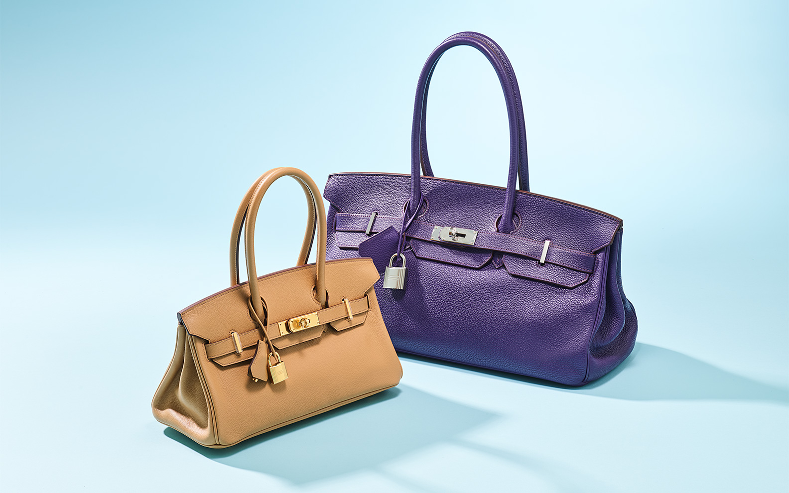 Left, a biscuit evercolor leather shoulder birkin light 29 with gold hardware, Hermès, 2025. Estimate: HK$140,000-200,000. Right, an iris clémence leather jpg shoulder birkin 42 with palladium hardware, Hermès, 2010. Estimate: HK$40,000-60,000. Both offered in Handbags Online: the Hong Kong edit, until 14 July at Christie’s Online 