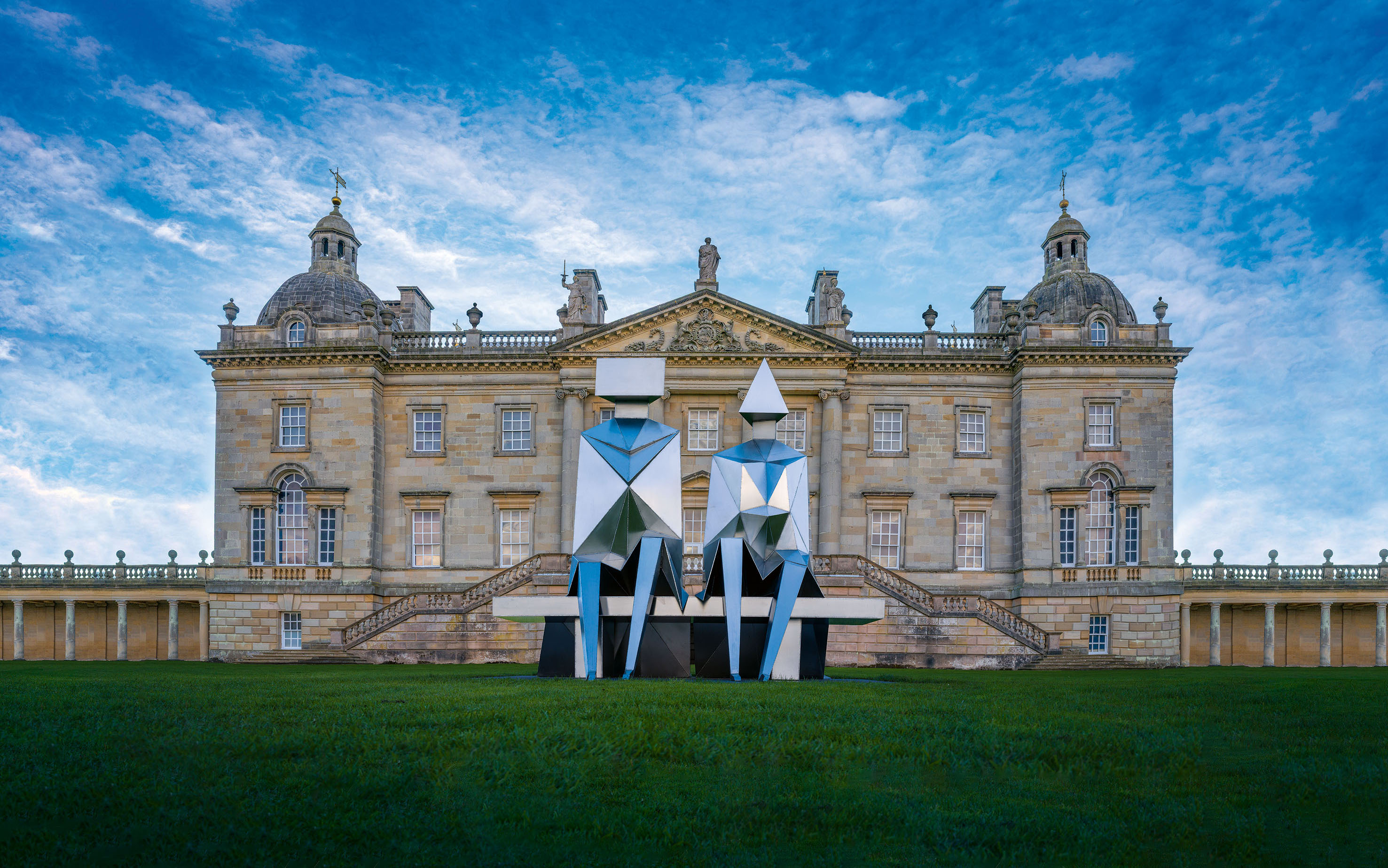 The Palladian facade of Houghton Hall is a magnificent backdrop to Lynn Chadwick's Sitting Couple on Bench, 1990