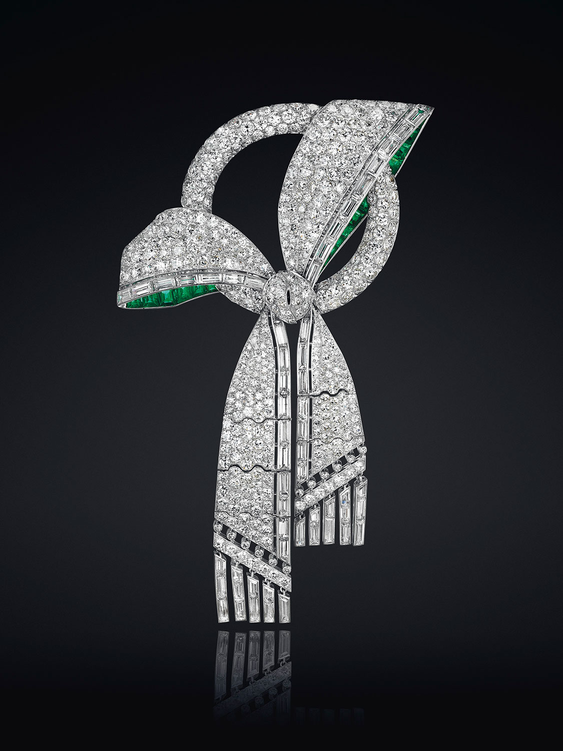 An Art Deco diamond and emerald bow brooch. Estimate: $20,000–30,000. This piece is offered in Magnificent Jewels & the Jubilee Ruby on 20 April at Christie’s New York