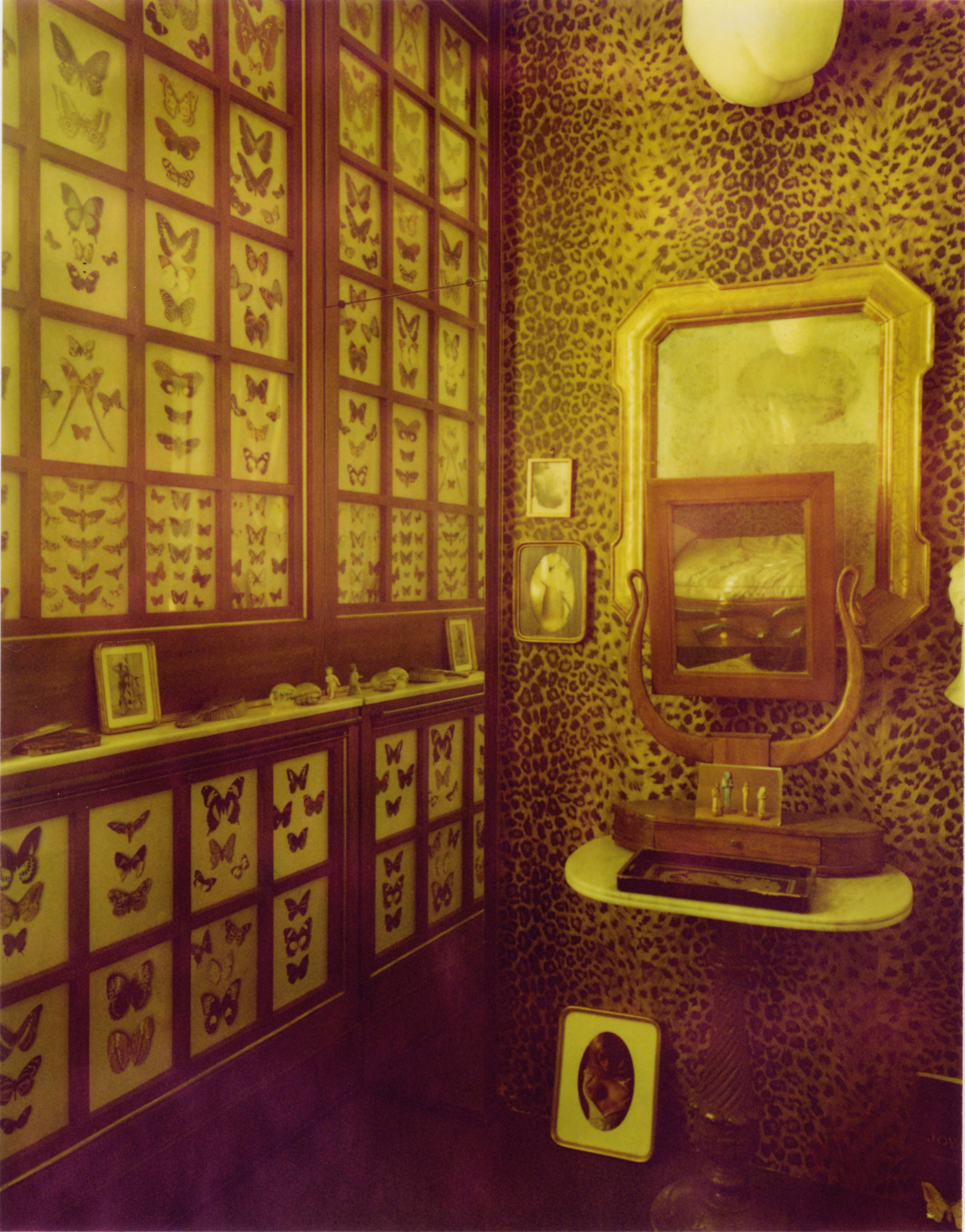 The bedroom, with its leopard-skin wall covering and collection of framed butterflies. Photograph by Alberto Zanetti