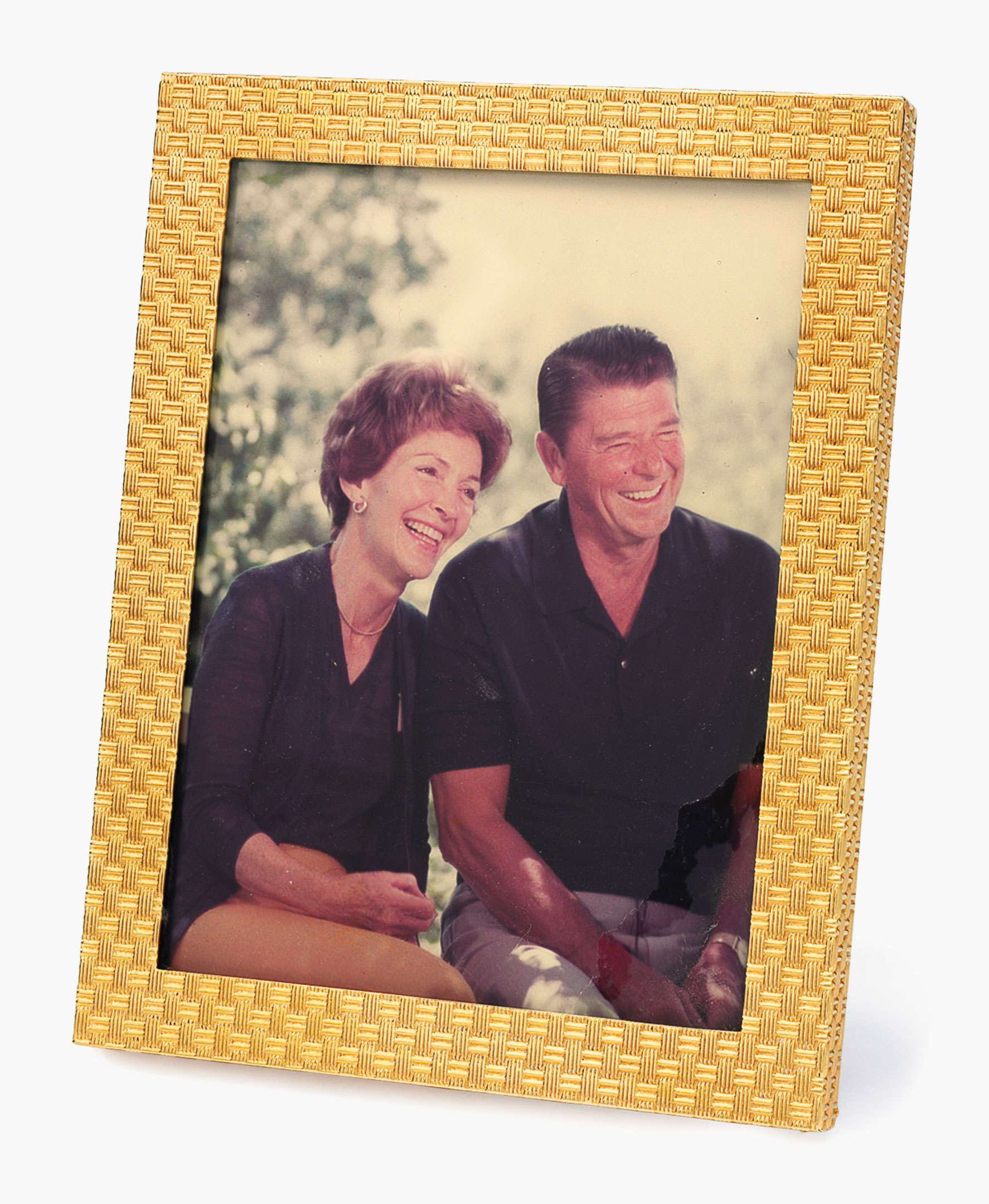 A gold picture frame. The 14k-gold frame of basketweave design, with picture of President and Mrs. Reagan. 4 &frac12; x 3 &frac12; ins. This frame was displayed in the White House while President Reagan was in office. Estimate: $1,000-1,500. This lot will be offered in The Private Collection of President and Mrs. Ronald Reagan, 21-22 September at Christie's in New York