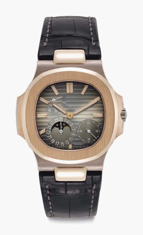 Patek Philippe. An 18k pink and white gold automatic wristwatch with moon phases, date, and power reserve. Signed Patek Philippe, Gen&egrave;ve, retailed by Tiffany &amp; Co., Nautilus Model, Ref. 5712GR, Movement No. 5'570'879, Case No. 4'530'649, Manufactured in 2006. This lot was offered in Rare Watches including NAUTILUS 40 part IV on 6 December 2016 at Christie&rsquo;s in New York and sold for $37,500