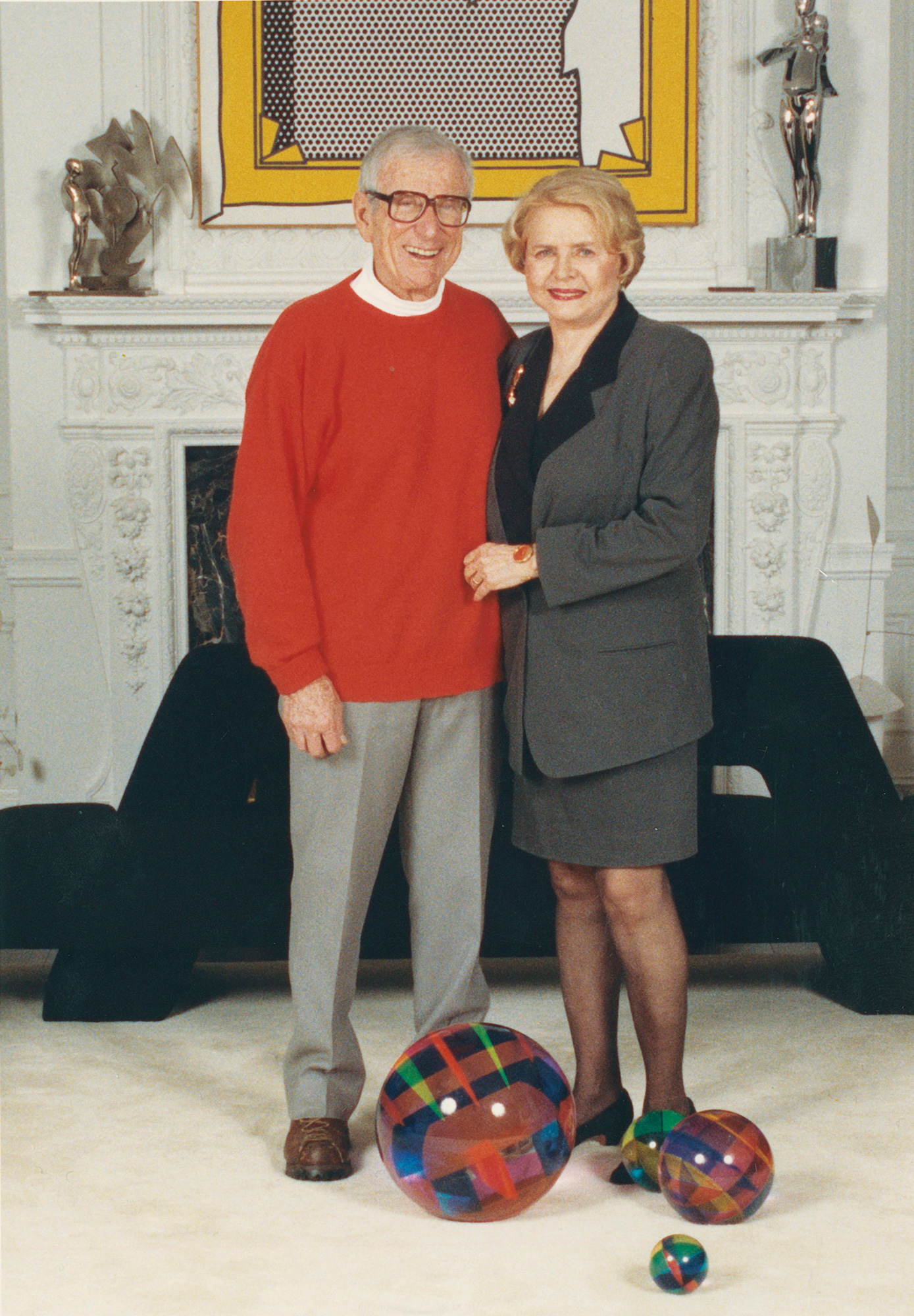 Edna and Stanley Tuttleman standing in front of Roy Lichtenstein’s 1973 trompe l’oeil masterwork Stretcher Frame Revealed Beneath Painting of a Stretcher Frame