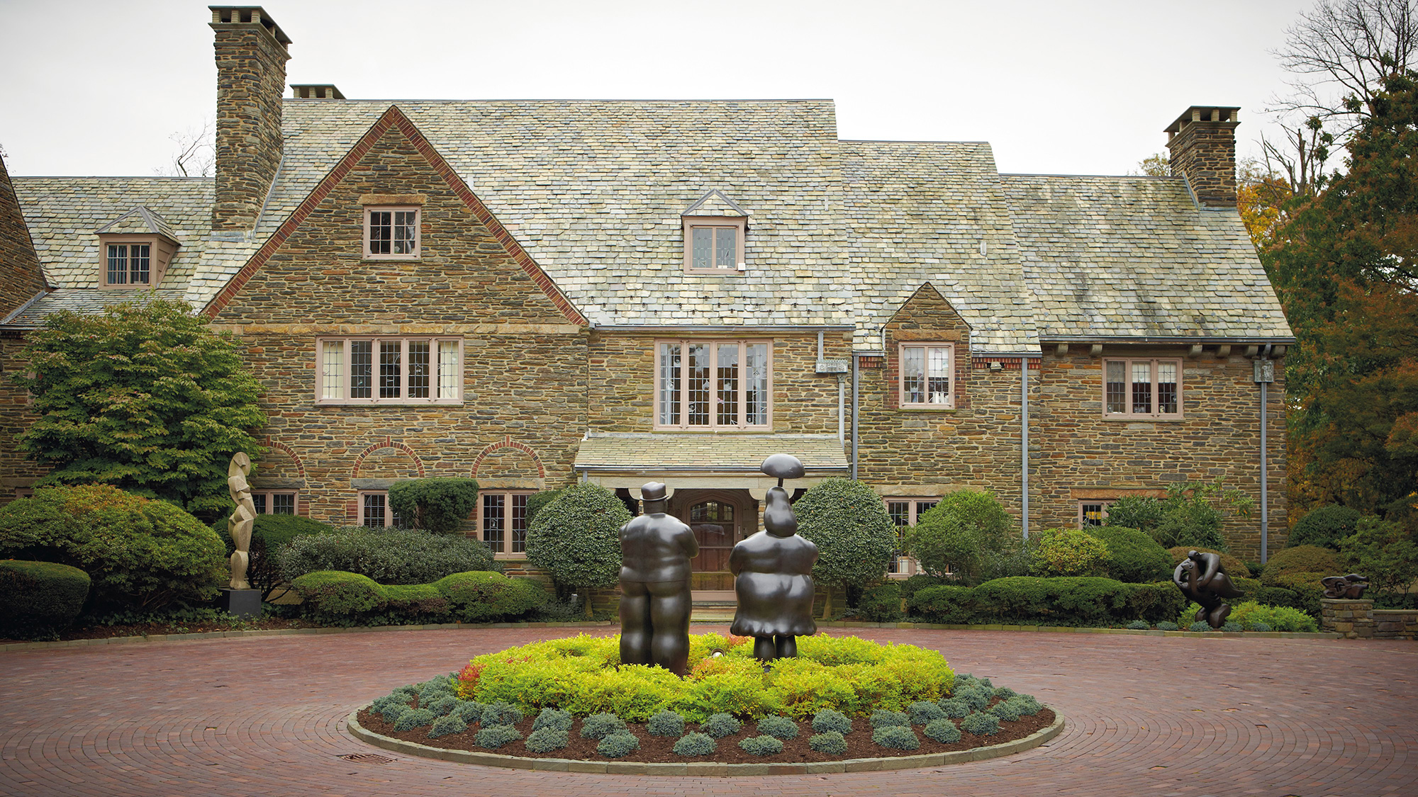 The exterior of the Tuttlemans’ Pennsylvania home. Centre: Fernando Botero (b. 1932), Woman with Umbrella & Man with Cane, c. 1977. Bronze. Artist’s proof one of two; edition of six. 90 x 35 x 30 in (228.6 x 88.9 x 76.2 cm). Estimate: $1,000,000-1,500,000. This work is offered in Latin American Art on 24-25 May at Christie’s in New York