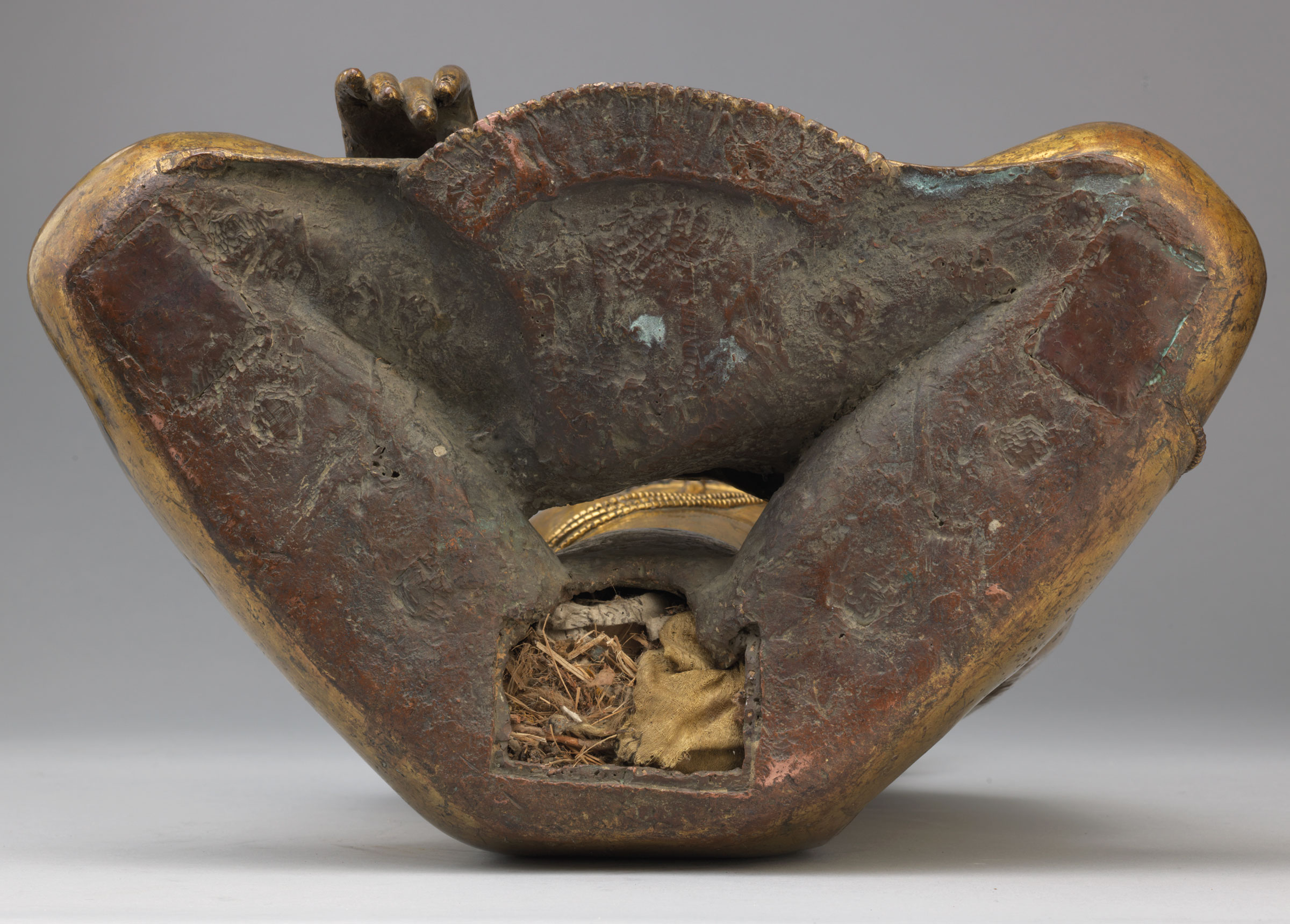 Generally, there will be a cavity at the bottom or back of sculptures such as this, which is filled with materials. In this example the materials have been preserved inside