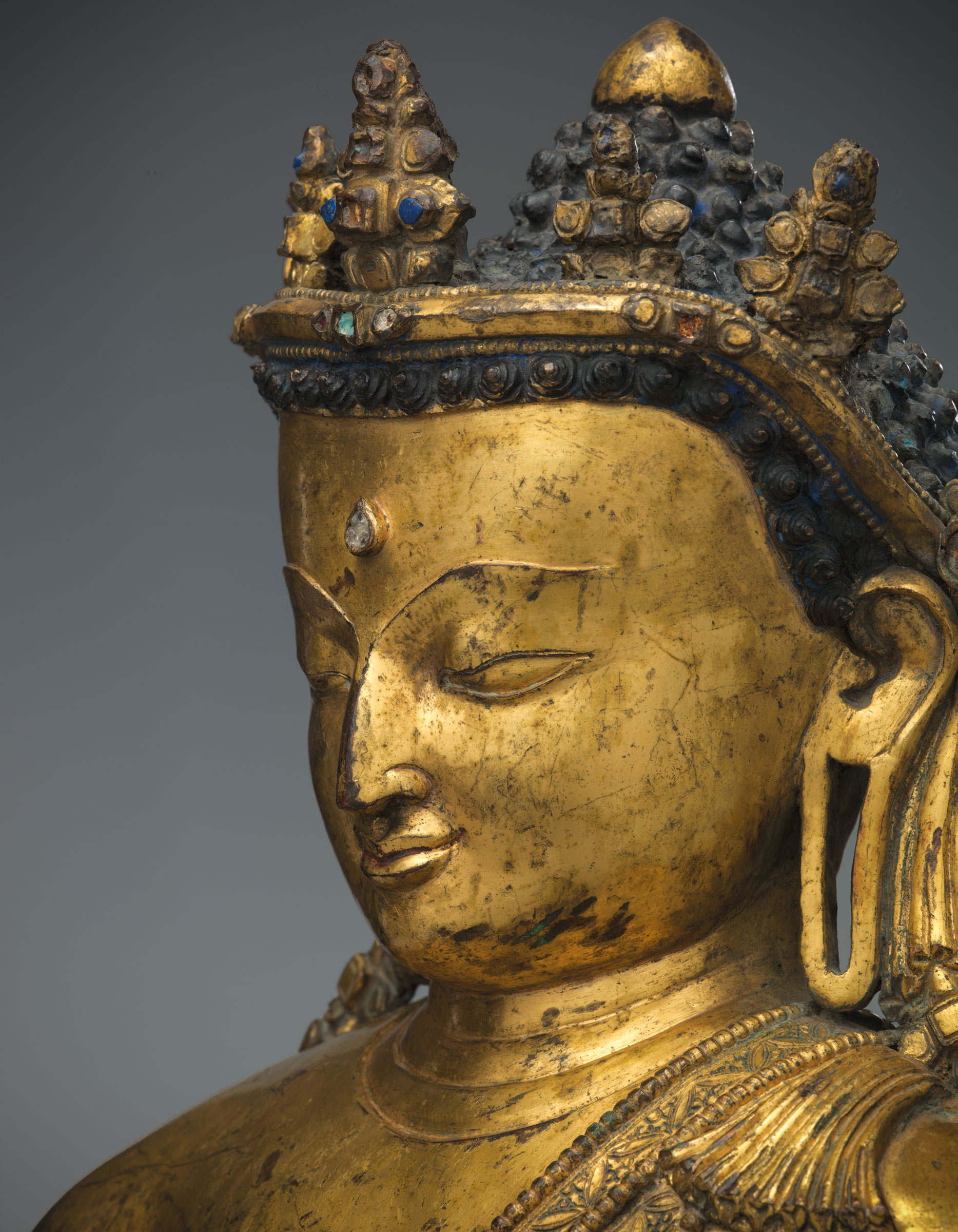In this gilt Buddha, the influence of Pala art — an important sculptural style that reached its peak in Northeast India in the 12th century — can be seen in the profile, particularly the long, protruding nose
