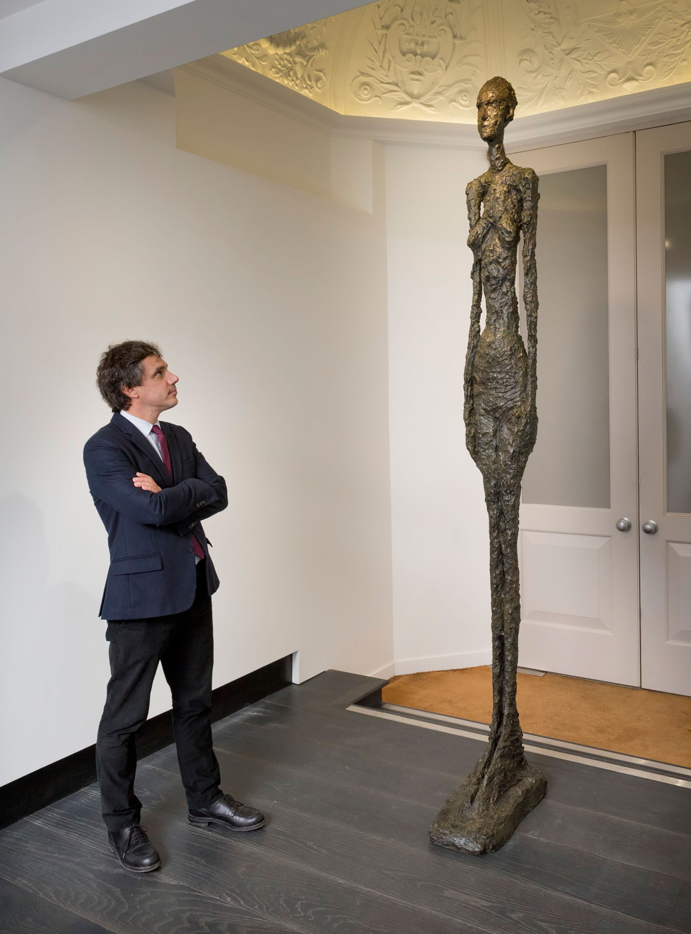 Pierre Martin-Vivier with Alberto Giacometti, Grand Femme II. Bronze with dark brown patina. Height: 108⅞ in (276.5 cm). Conceived in 1960; this bronze cast in 1980-81 © The Estate of Alberto Giacometti (Fondation Annette et Alberto Giacometti, Paris and ADAGP, Paris), licensed in the UK by ACS and DACS, London 2017