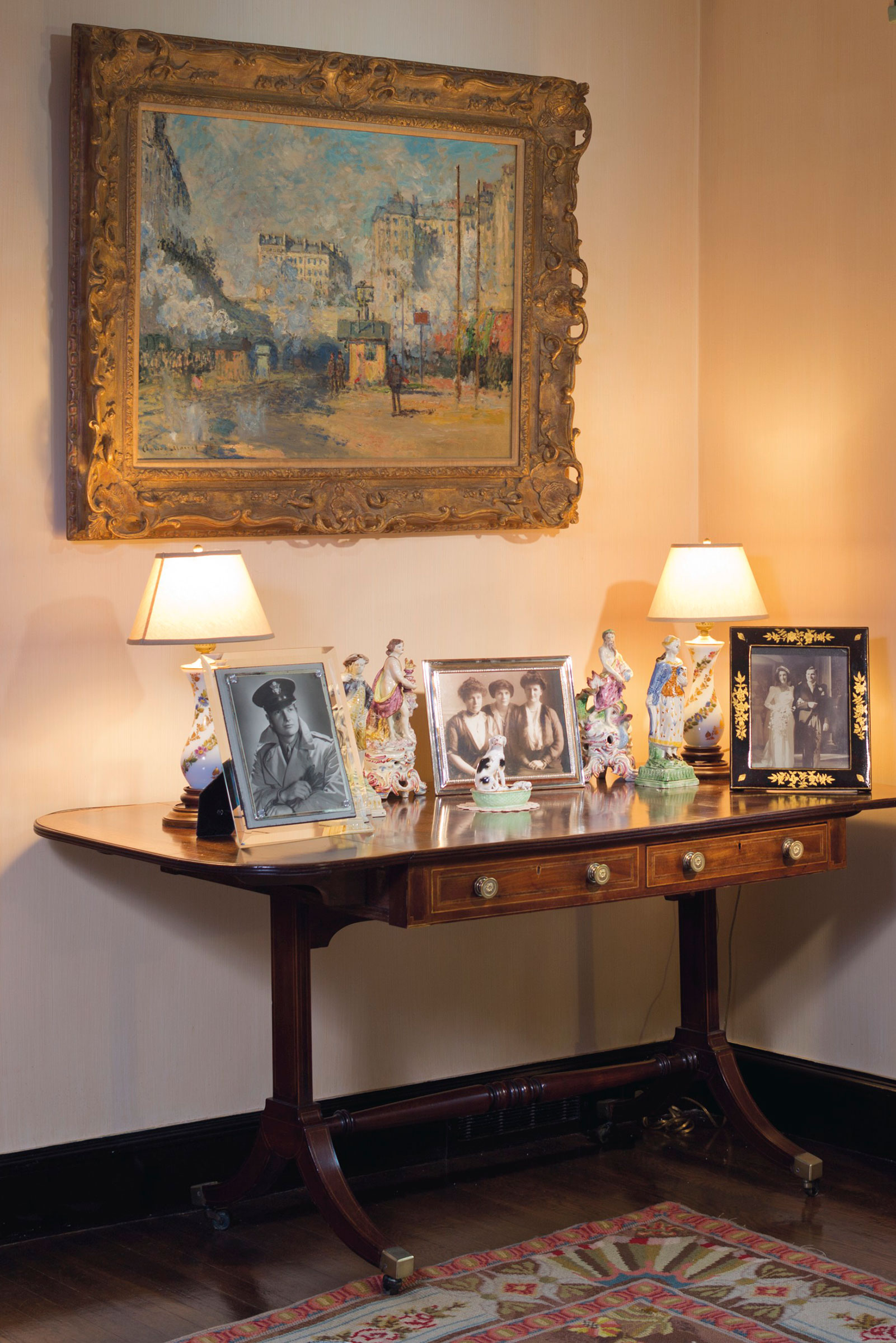 Ext&eacute;rieur de la gare Saint-Lazare, effet de soleil, by Claude Monet, in the bedroom at Hudson Pines, hung above a late Regency mahogany, bird's eye maple and Indian Rosewood sofa table displaying, among other items, a pair of Bow figures emblematic of Fire and Water