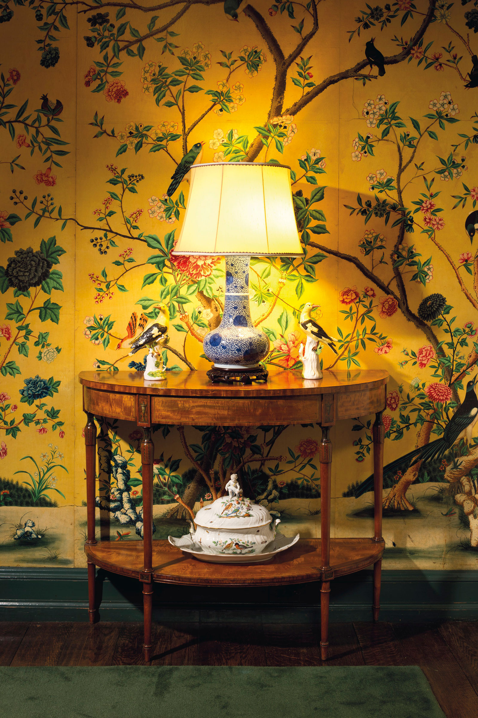 The dining room in the Manhattan home of Peggy and David Rockefeller, featuring a pair of Meissen models of golden orioles on one of a pair of George III inlaid painted satinwood side tables

