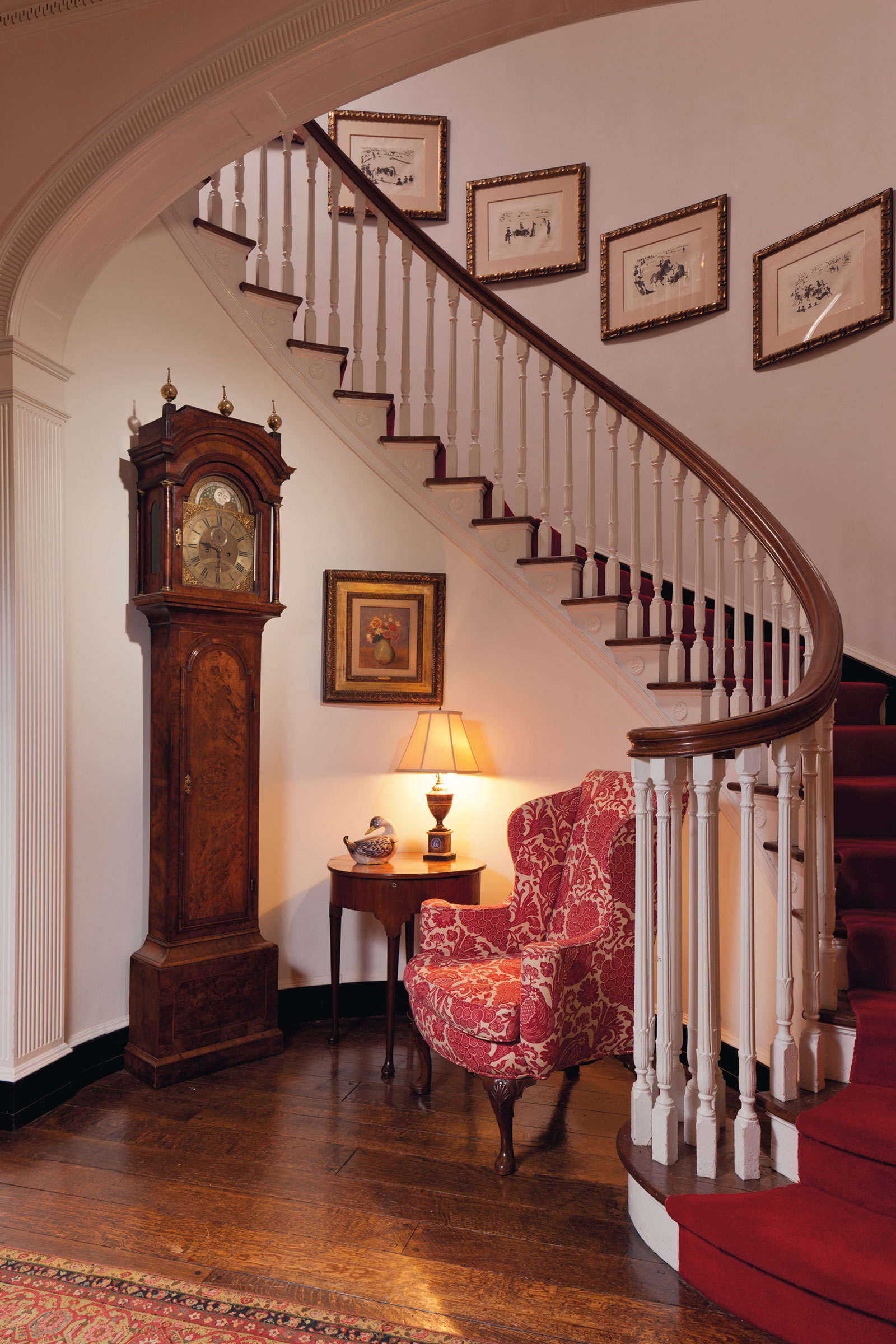 
The entrance hall, featuring a George II walnut wing armchair and, along the stairs, works from Picasso&rsquo;s bullfighting series
