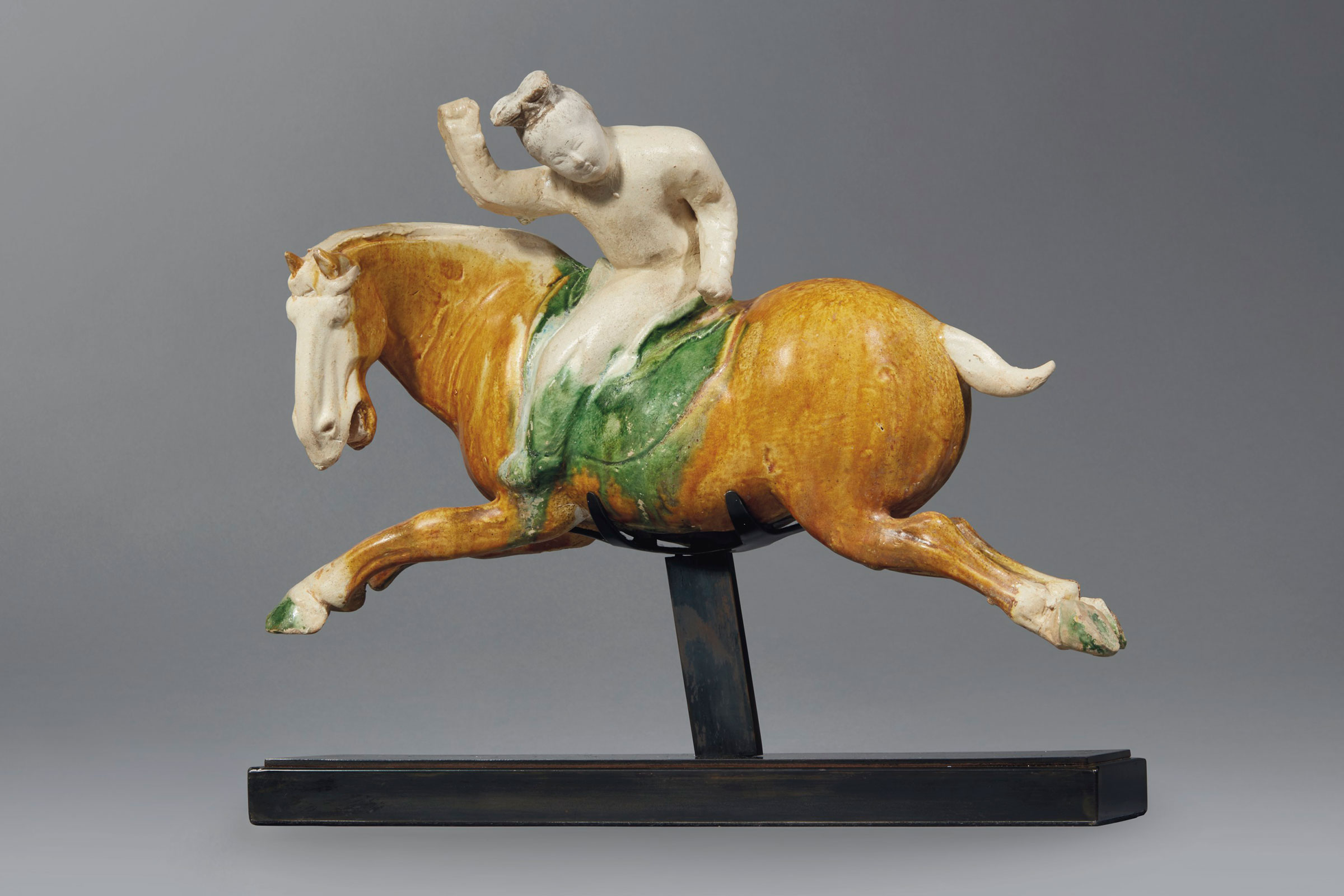 A very rare and important sancai-glazed pottery figure of a female polo player, Tang dynasty (AD 618-907). 13¾  in (35  cm) long, metal stand, cloth box. Sold for $372,500 on 14-15 September 2017 at Christie’s in New York