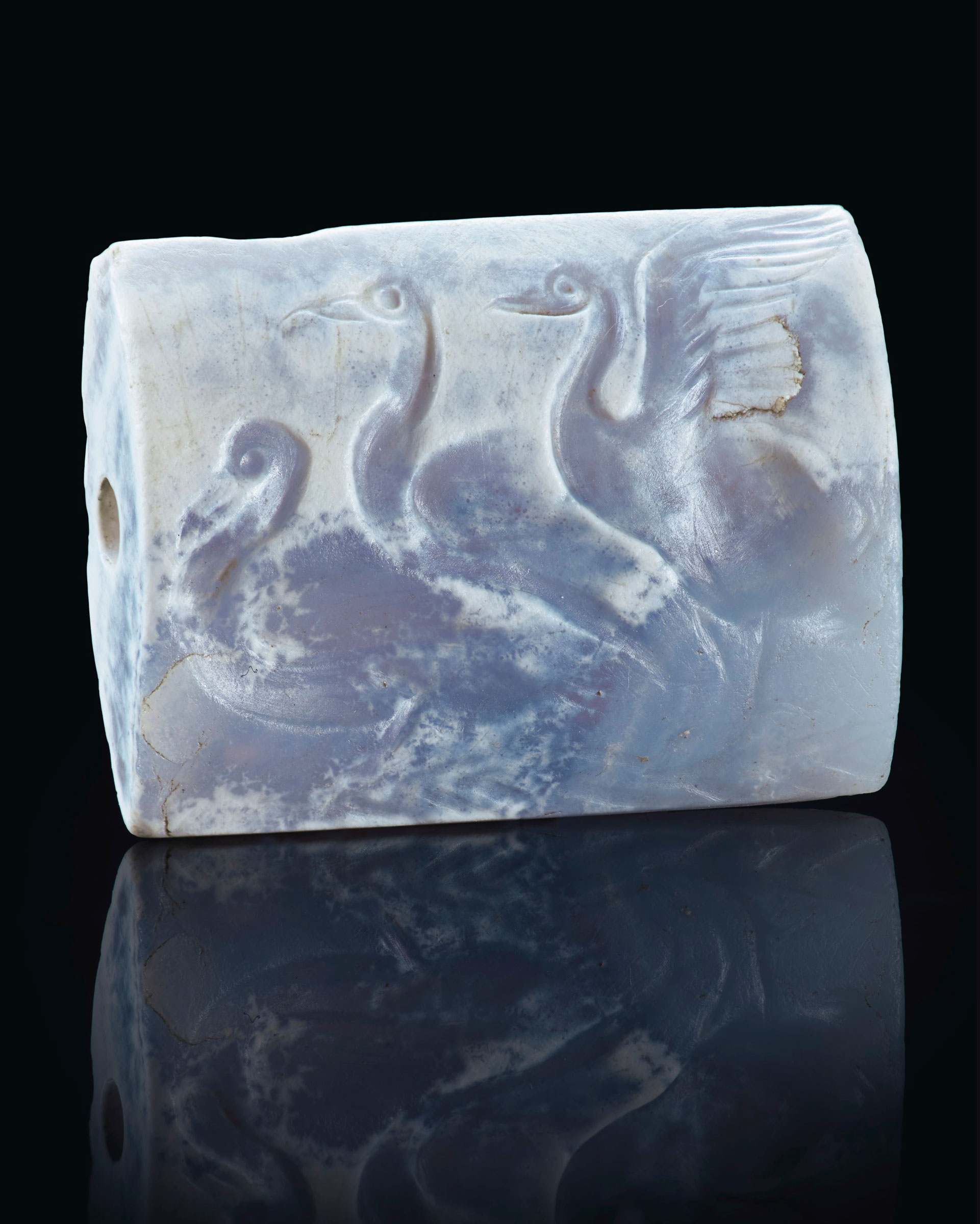 A Minoan blue chalcedony tabloid seal with three swans, Late Palace period, c. 16th century BC. ¾in (1.9  cm) long. Sold for $118,750 in Masterpieces in Miniature: Ancient Engraved Gems formerly in the G. Sangiorgi Collection on 29 April 2019 at Christie’s in New York