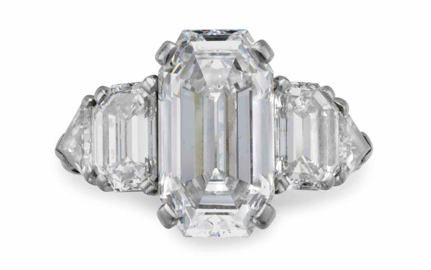 In 1940 David Rockefeller purchased this ring set with a cut-cornered rectangular step-cut diamond, weighing approximately 5.63 carats, with epaulet and triangular-cut diamond shoulders, from Raymond Yard. He presented the ring to Peggy McGrath upon their engagement. In 1959 the ring was returned to Raymond Yard, who altered the design, integrating additional diamonds on either side of the centre diamond. Sold for $287,500 on 12 June 2018 at Christie’s in New York