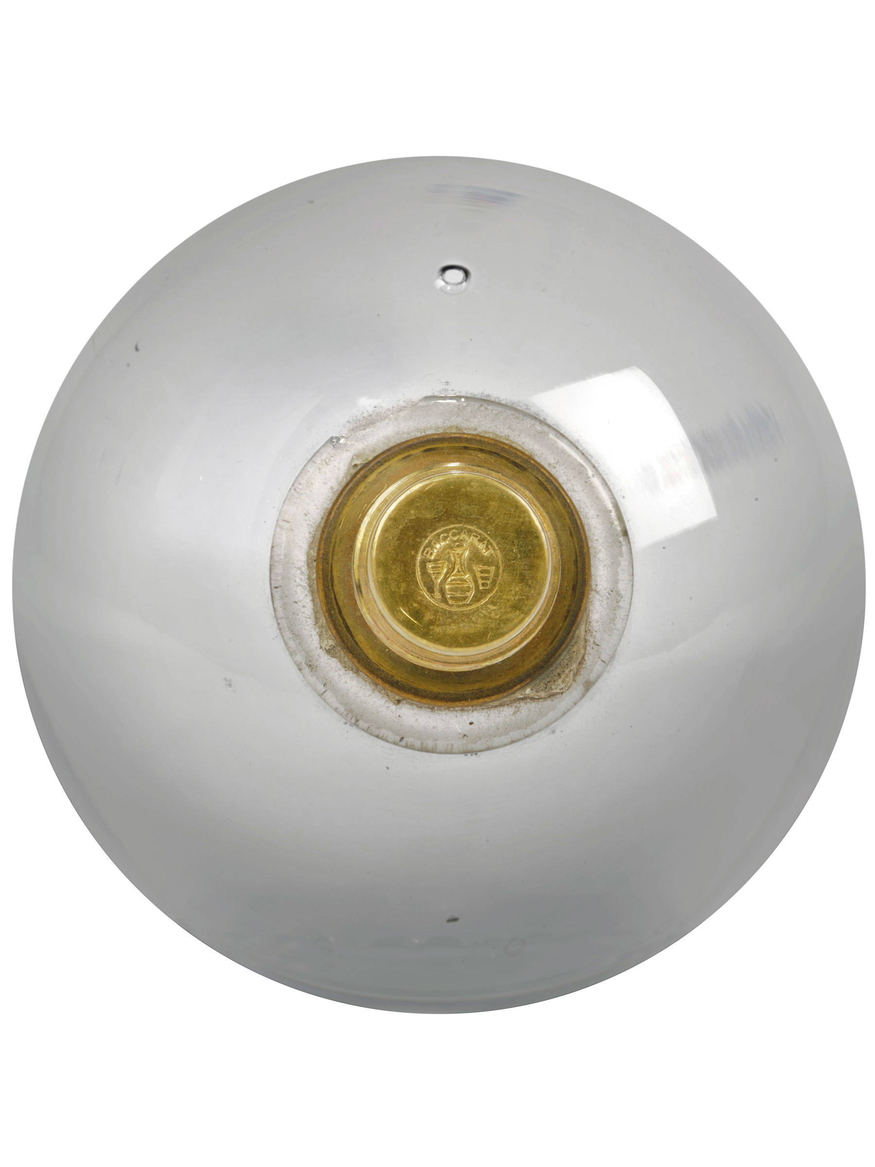 The gilt-bronze at the base of the solid glass orb &mdash; or boss &mdash; to the underside of the chandelier is signed with the Baccarat mark depicting a carafe between a wine glass and a goblet