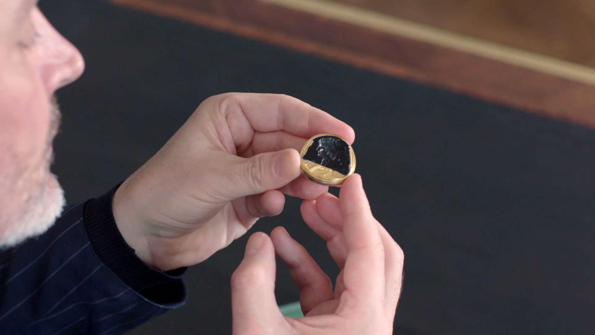 Marc Auclert holding a&nbsp;Roman black chalcedony intaglio portrait of Antinous, Circa 130-138 AD. 1⅜  in (3.4  cm) long. Sold for $2,115,000 on 29 April 2019 at Christie&rsquo;s in New York