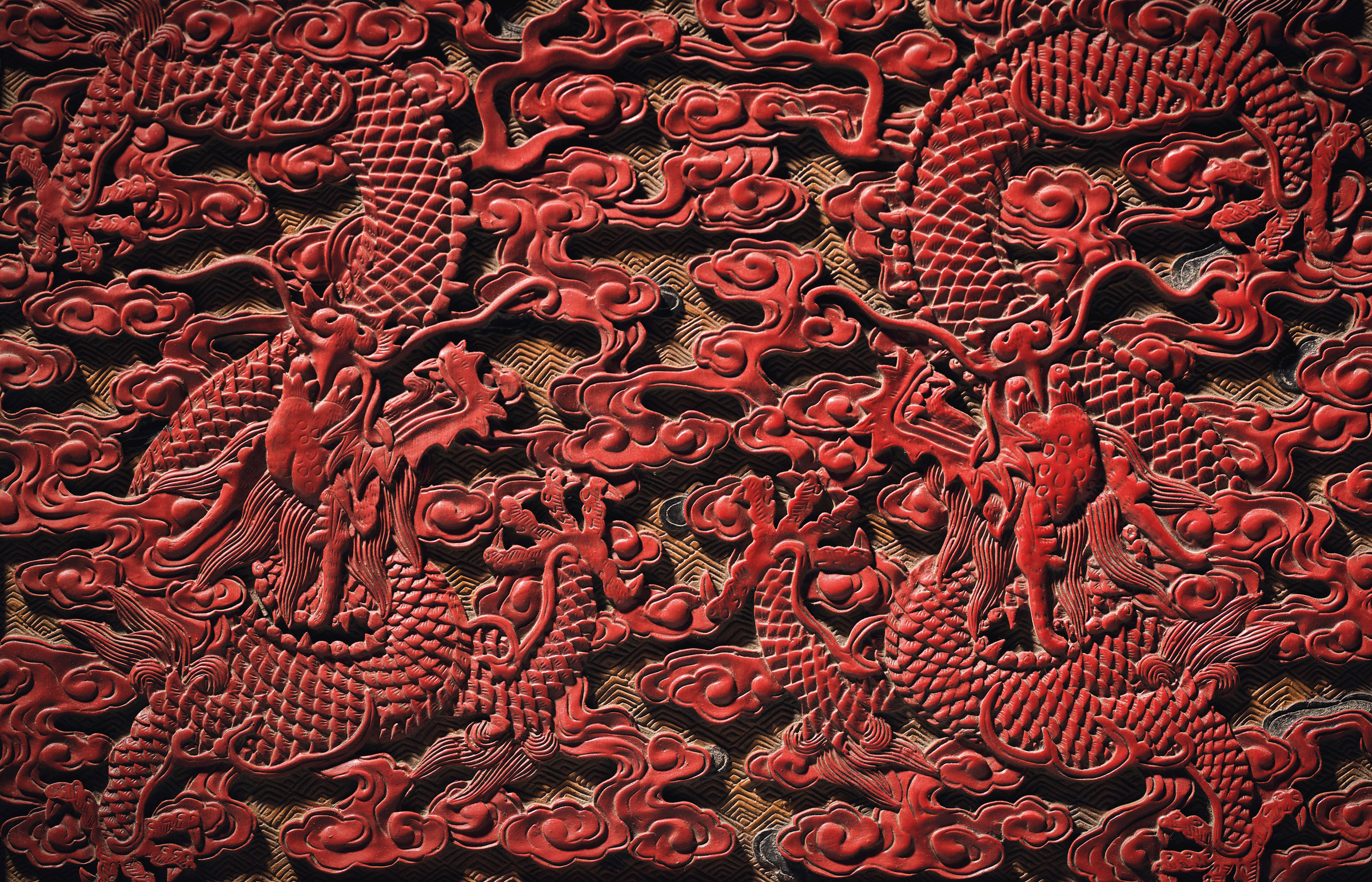 Two of the nine five-clawed dragons on the throne, finely carved in red lacquer