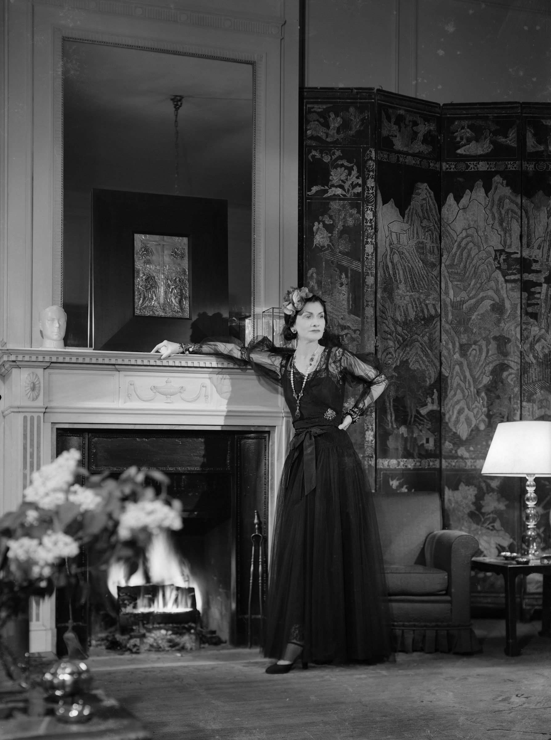 Coco Chanel photographed in her apartment at the Ritz in 1937. The glass case in which she kept the rock crystal deer can just be made out on the mantelpiece, behind her head. Photo © Ministère de la Culture — Médiathèque de l'architecture et du patrimoine, Dist. RMN-Grand Palais / François Kollar. © RMN — Gestion droit d'auteur François Kollar.