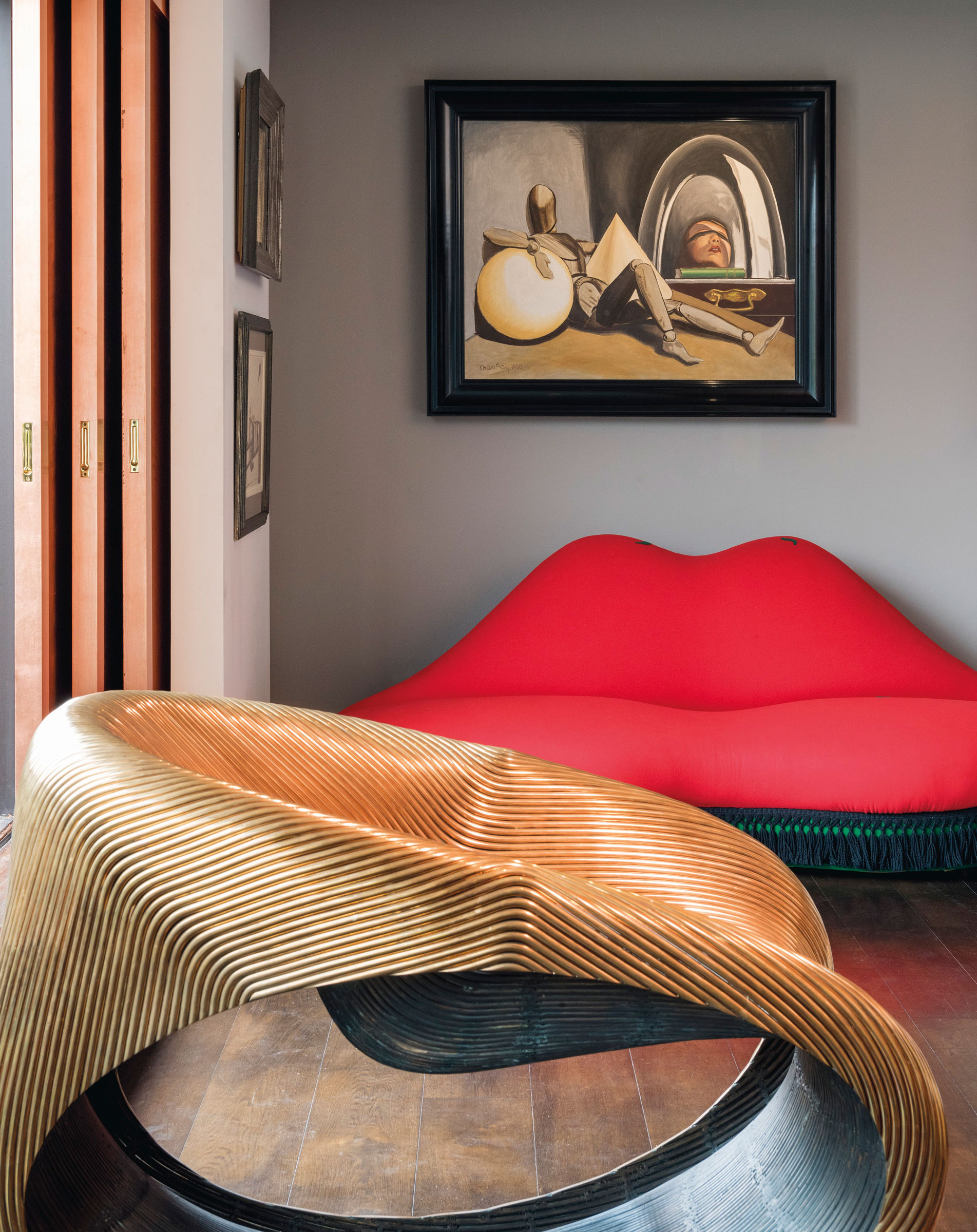 Interior view of the collector’s home, featuring Man Ray (1890-1976), Aline et Valcour, painted in Hollywood in 1950. 30 x 37⅞ in (76 x 96.4 cm). Estimate: £600,000-800,000. Salvador Dalí (1904-1989) & Edward James (1907-1984), Mae West Lips Sofa, conceived by Salvador Dalí and Edward James in 1936 and executed by Green & Abbott in 1938 as one of a pair for the dining room at Monkton House, West Sussex. 30⅓ x 80⅞ x 37¾ in (77 x 205.7 x 96 cm). Estimate: £400,000-600,000. Both offered in Impressionist and Modern Art Evening Sale on 18 June 2019 at Christie’s in London