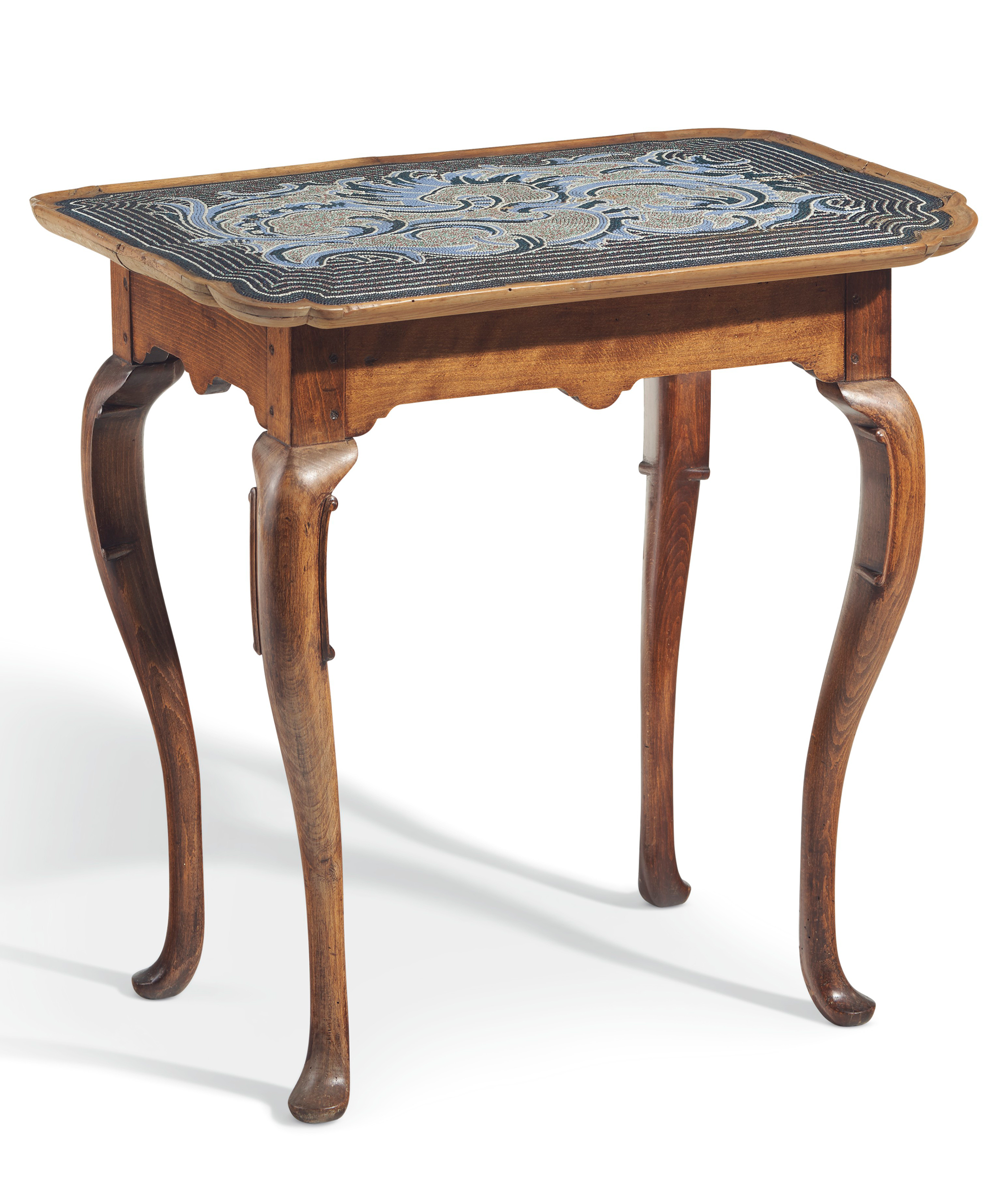 A German beechwood and beadwork centre table, Braunschweig, the beadwork attributed to Johann Michael Van Selow, circa 1740. The shaped rectangular beadwork top with stylised foliage on a striped ground, above a shaped apron, cabriole legs. 30¼ in (77 cm) high, 31in (79cm) wide, 21½ (54.5 cm) deep