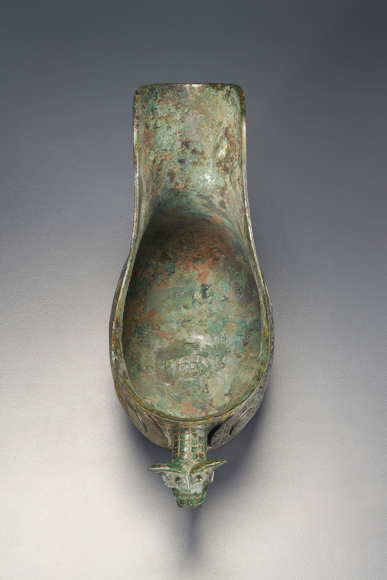 The interior of the gong showing its inscription &mdash; four footprints around what has been interpreted as two hands holding an album or book