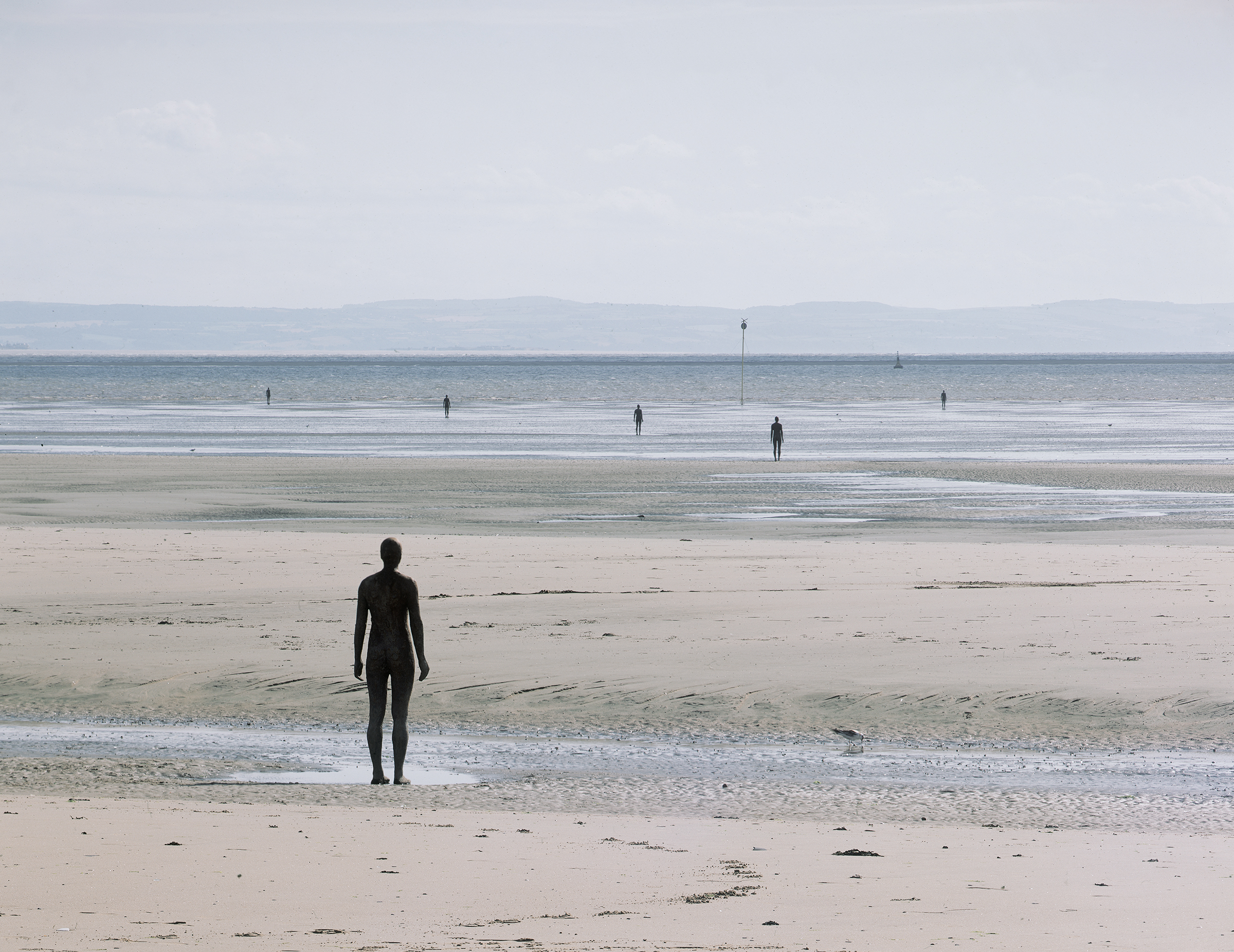 Antony Gormley (b. 1950), Another Place, 1997. Cast iron. 100 elements: each 189 x 53 x 29 cm. Installation view, Crosby, Merseyside, UK. Photo: Stephen White & Co. © the artist