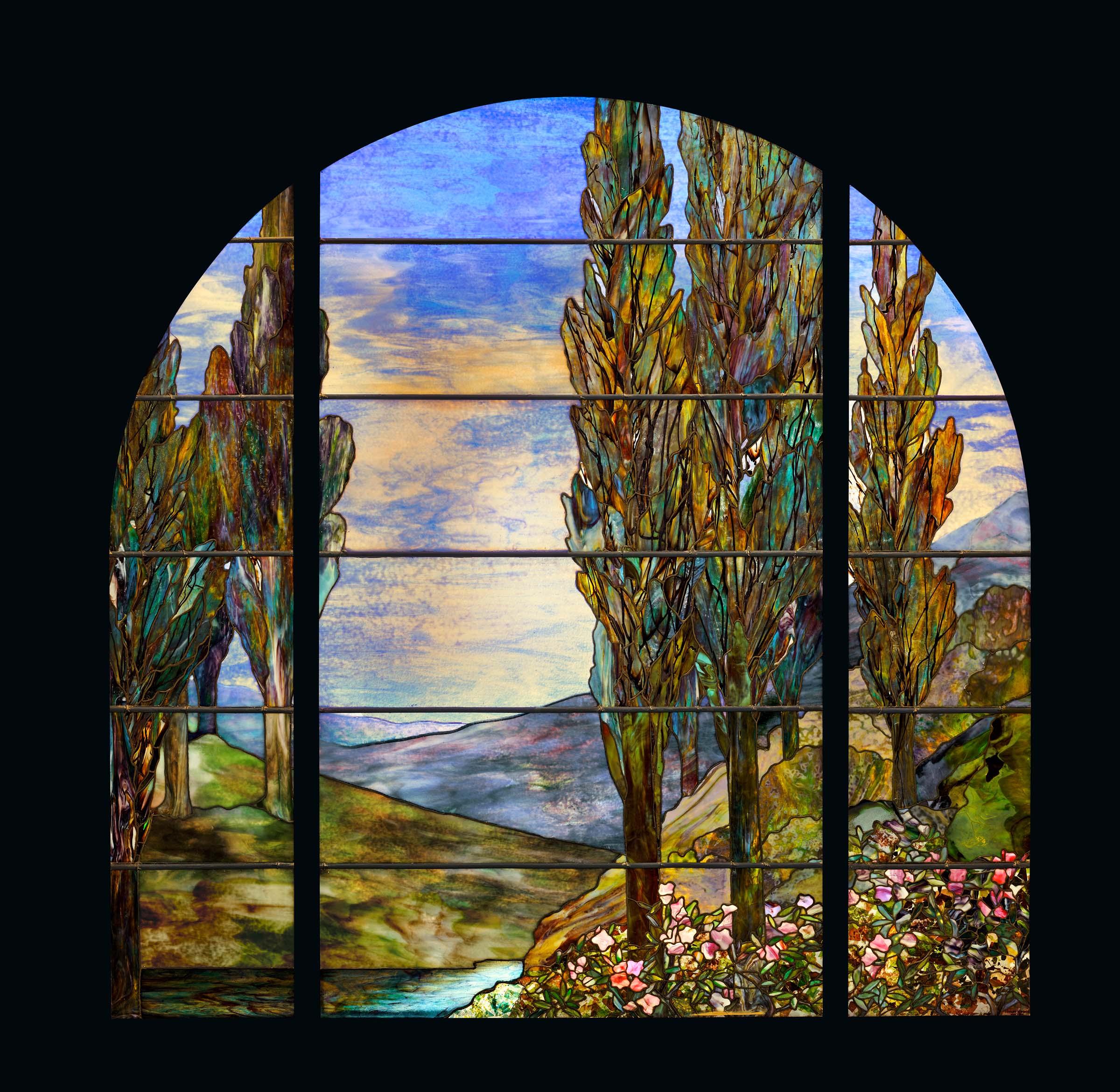 蒂芙尼工作室,“柏树与花”景观玻璃窗,约1908年制。含铅电镀玻璃。77 1/2 x 77 英寸(196.8 x 195.6 公分)。估价:300,000-500,000美元。此拍品将于2023年6月14日在佳士得纽约“戈登·盖蒂伉俪珍藏:Temple of Wings大宅”拍卖中呈献