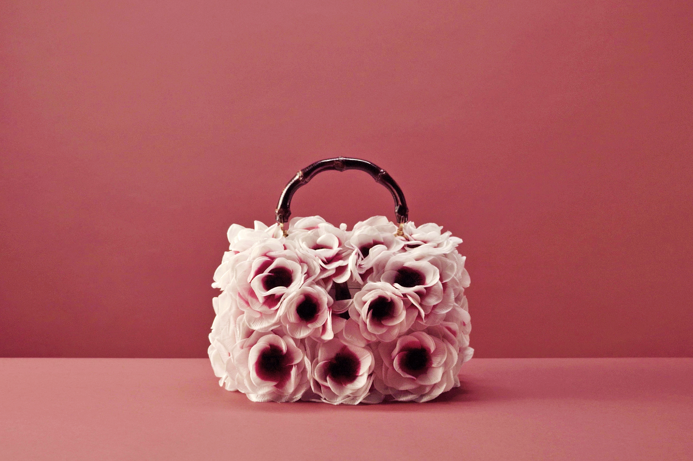 A unique Bamboo bag from Gucci Vault, which has been refashioned with a bouquet of silk flowers, meticulously cut and painted by hand, blooming over a smooth white leather surface