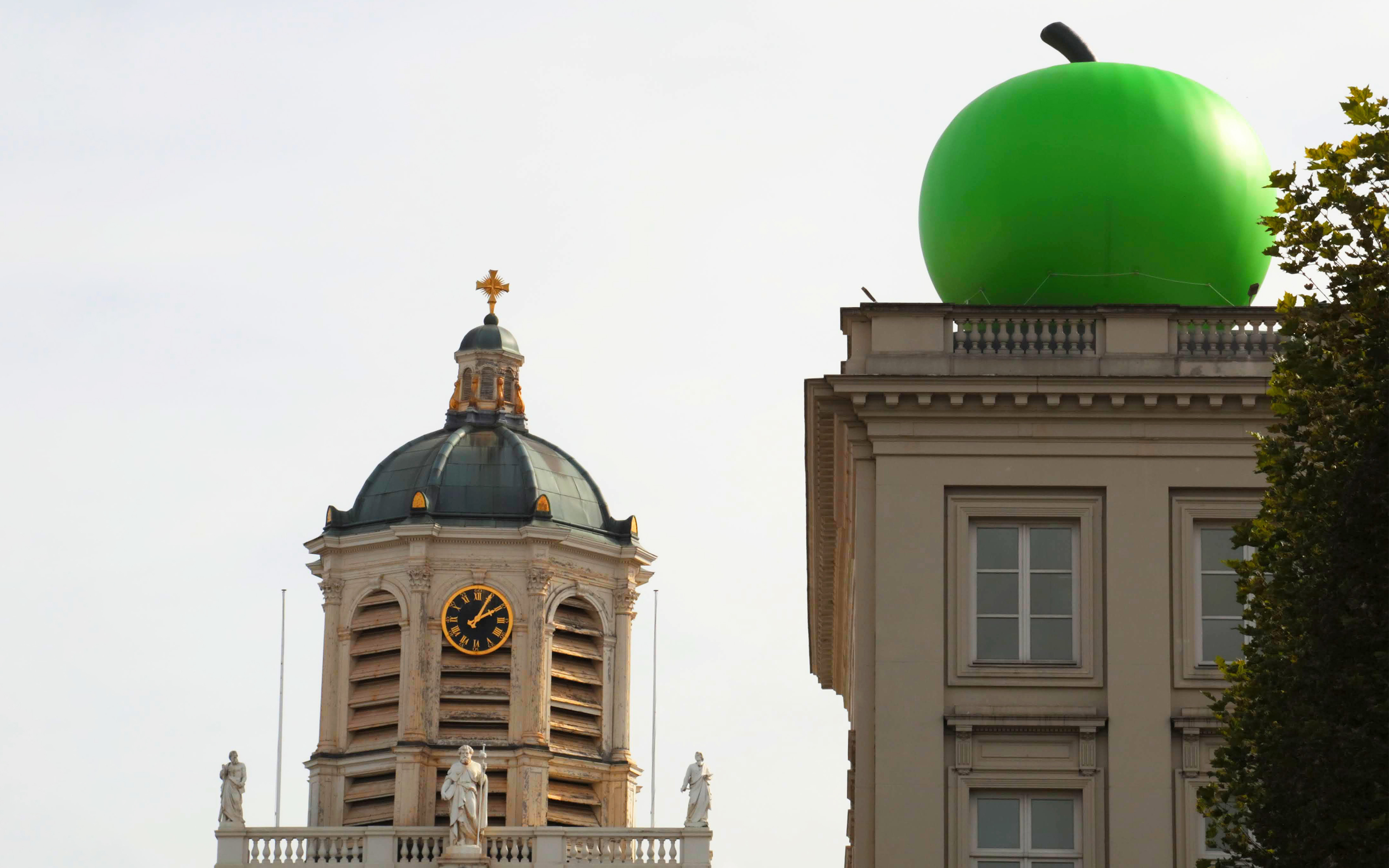 The Magritte Museum in Brussels, adorned with a monumental apple, one of Rene Magritte's recurring motifs, for its reopening in October 2023 following an extensive refurbishment, with the adjacent tower of the Church of Saint James on Coudenberg