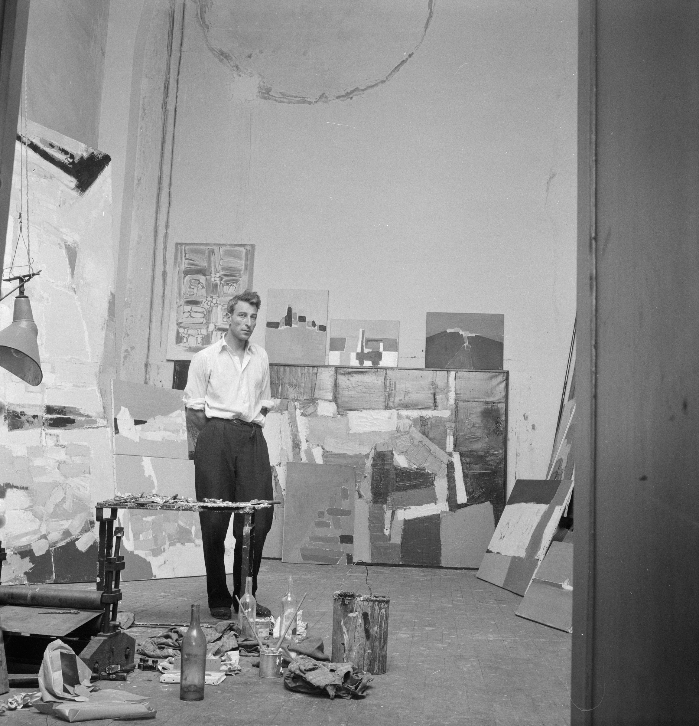 Nicolas de Stael at his studio on Rue Gauguet in Paris, photographed by Denise Colomb in 1954