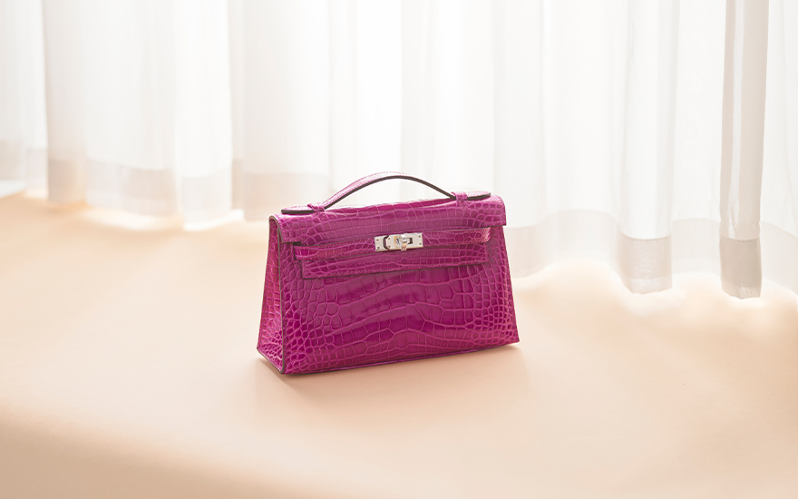 A shiny rose scheherazade alligator Kelly Pochette with palladium hardware, Hermes, 2019, offered in Handbags and Accessories on 25 May 2024 at Christie's in Hong Kong