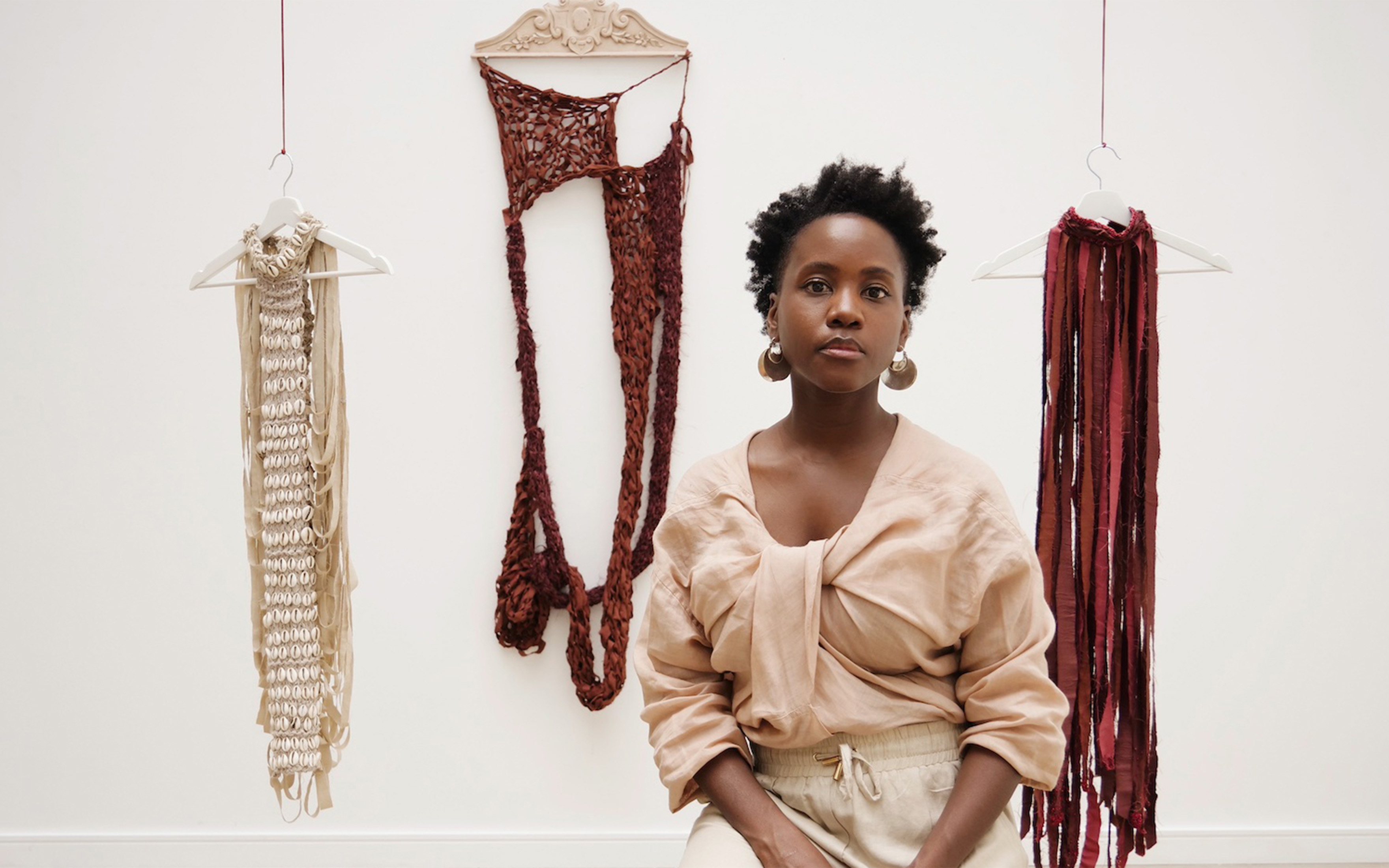 British-Ghanaian artist Enam Gbewonyo with her works Dellu Costume - Plant (Xob), Suuf (Earth) Altar I and Dellu Costume - Red Earth (Suuf)