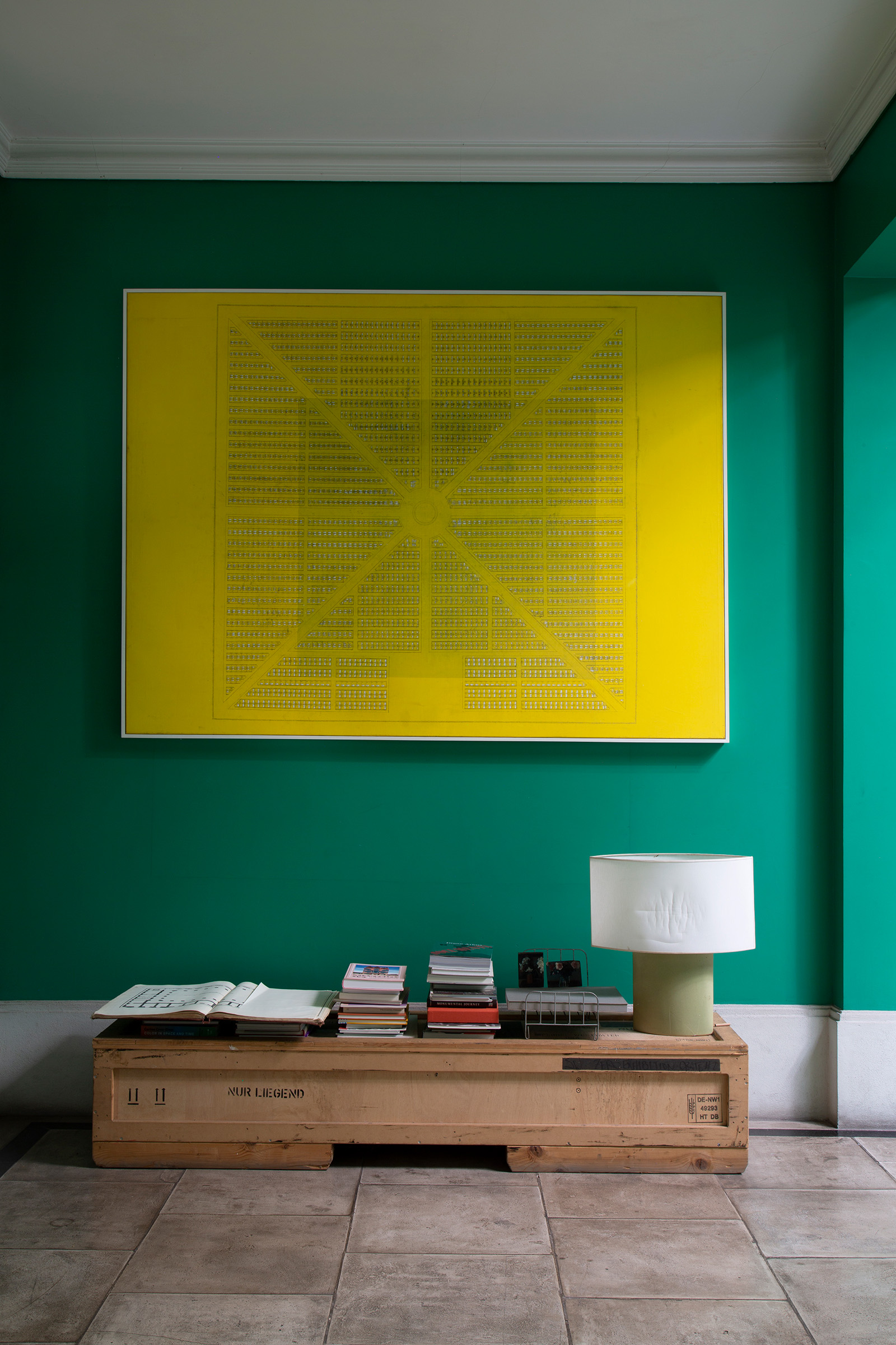 The entrance hall of Guillermo Kuitca's refurbished hotel in Buenos Aires, with works by the artist stacked like books beneath Carcel amarilla, 1994